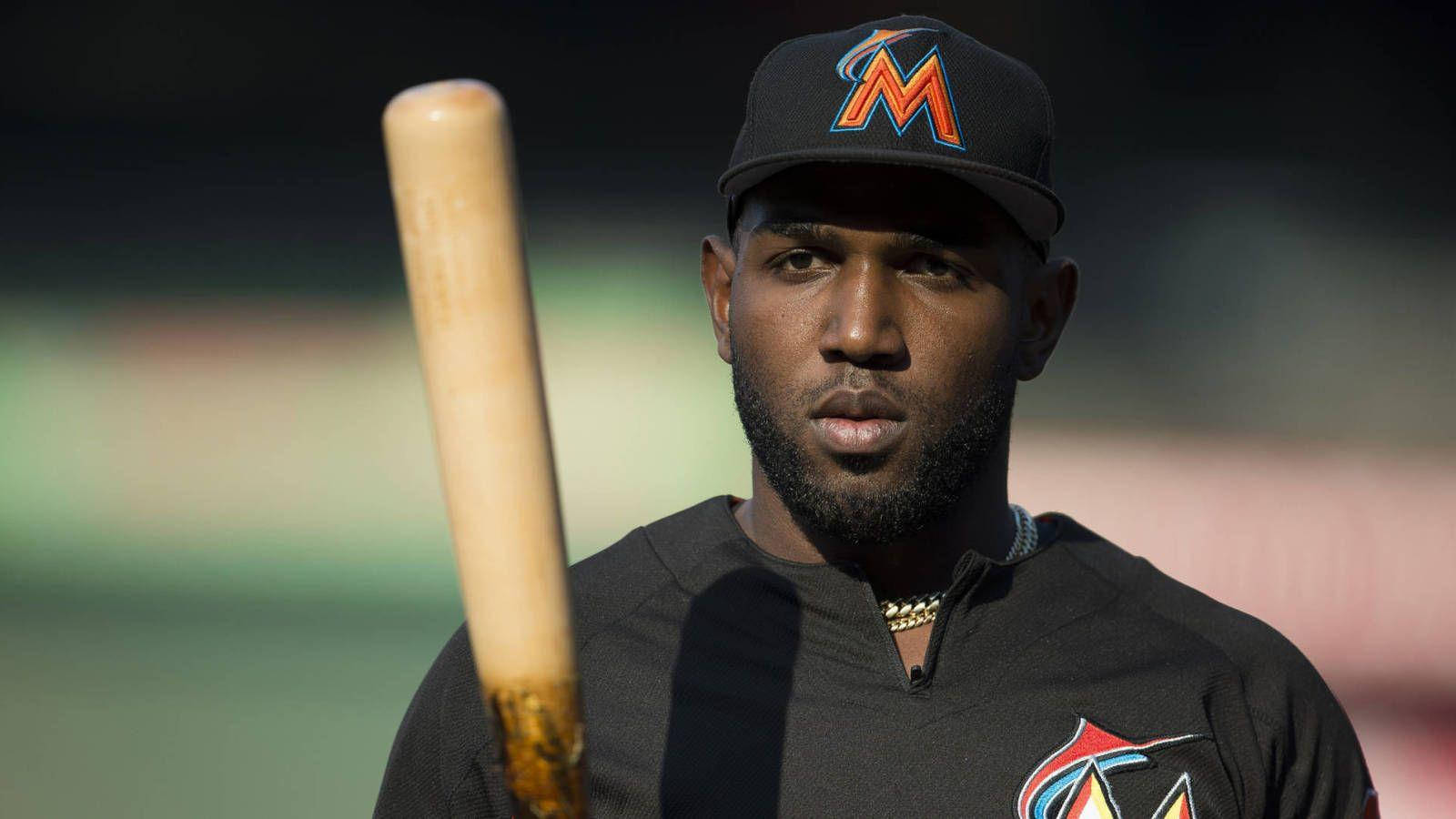 MLB 桌布 壁紙 — 一位專注的棒球運動員身穿邁阿密馬林魚隊制服，在模糊的球場背景下握著木製球棒。