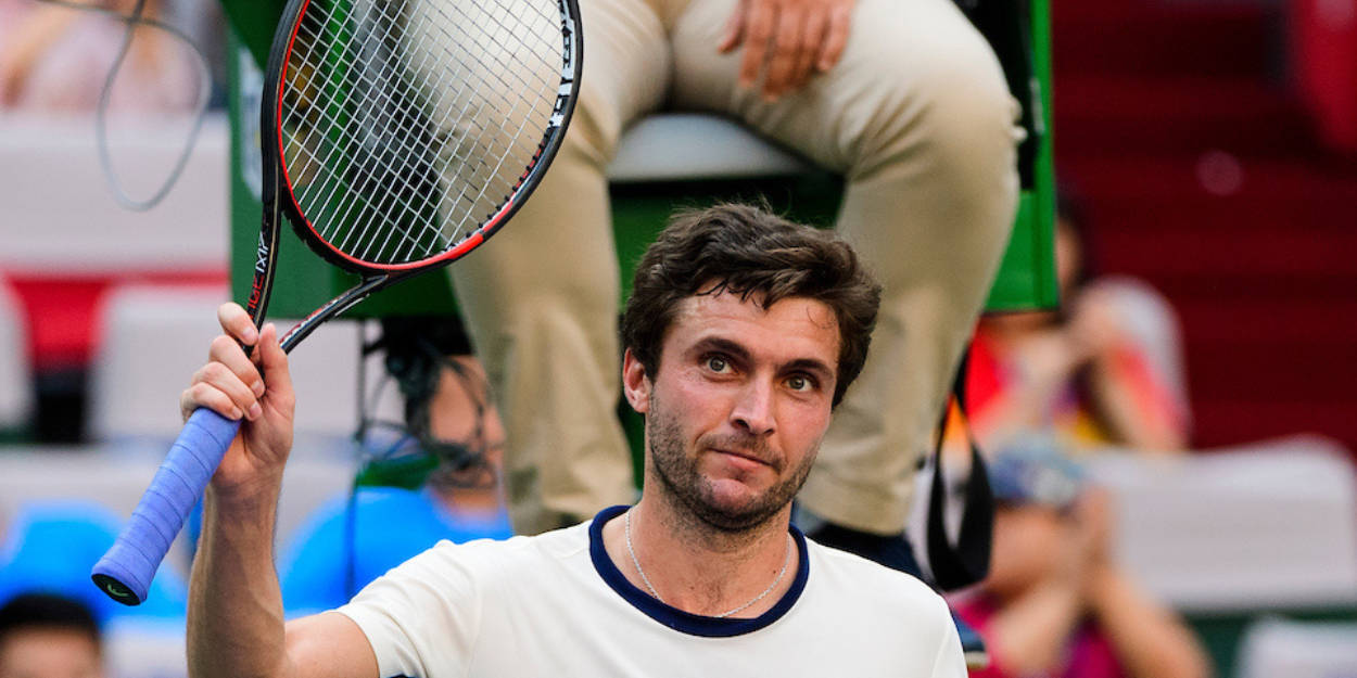 Tennis 桌布 壁紙 — 一位專注的男性網球運動員在比賽期間於體育場人群中高舉球拍。