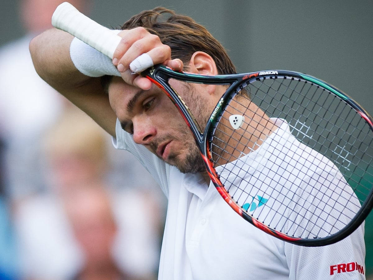 Tennis 桌布 壁紙 — 一位專注的男性網球運動員在緊張的比賽時刻將球拍握在頭部附近。