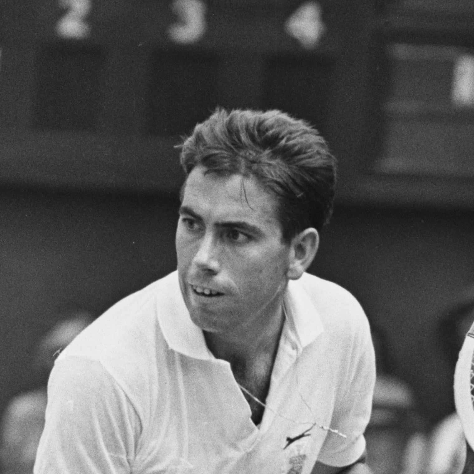 Tennis 桌布 壁紙 — 一位專注的男性網球運動員穿著白色襯衫，在比賽中專注地注視球場。