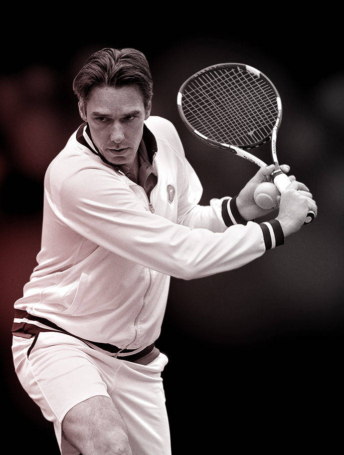 Tennis 桌布 壁紙 — 一位專注的男性網球運動員身穿白色服裝，準備在黑暗模糊的背景前用球拍擊球。