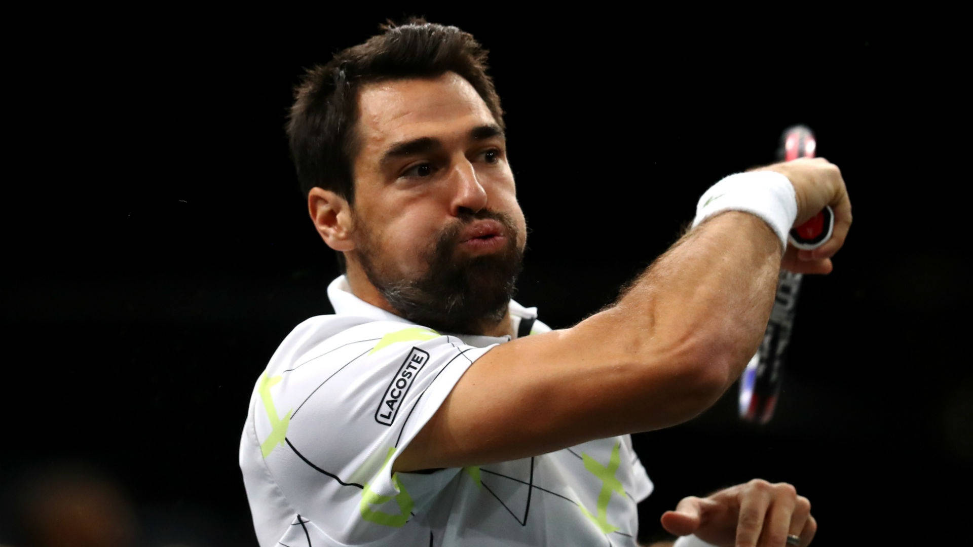 Tennis 桌布 壁紙 — 一位專注的男性網球選手在揮拍中，表情強烈，背景黑暗。