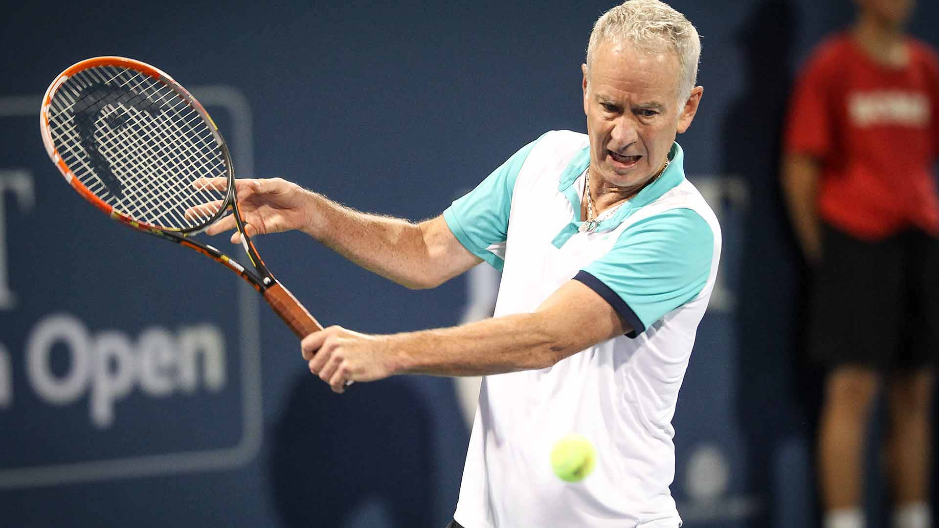 網球 桌布 壁紙 — 一位專注的男性網球選手在明亮燈光下的職業比賽中揮拍擊打黃色網球。