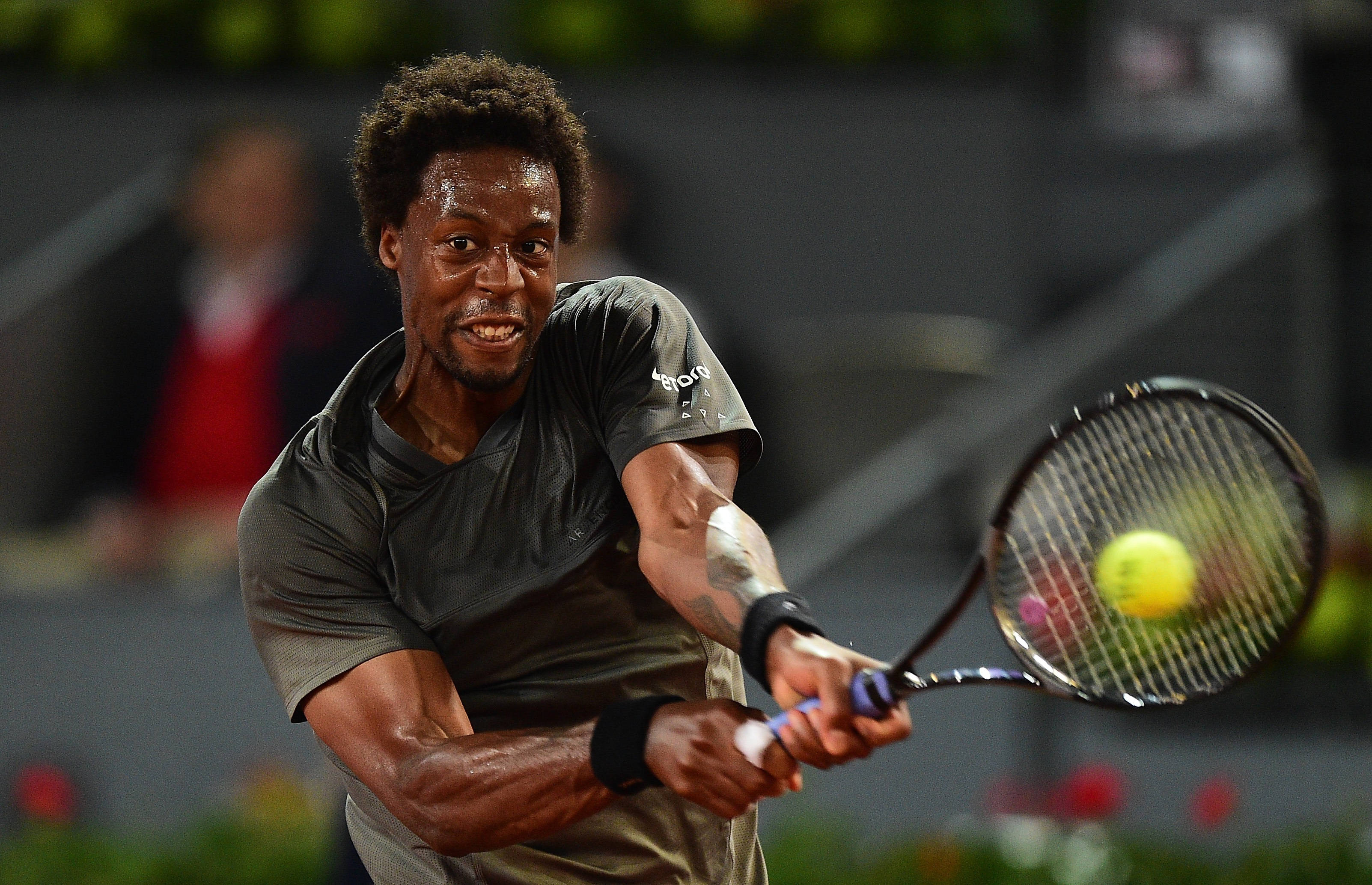 Tennis 桌布 壁紙 — 一位專注的男性網球選手在激烈的夜間比賽中揮拍擊打亮黃色的球。