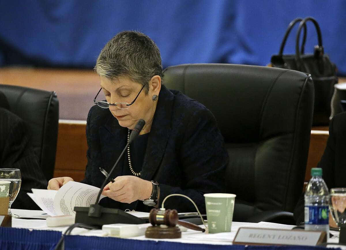 政治 桌布 壁紙 — 一位專注的短灰髮戴眼鏡女士在正式會議桌上閱讀文件，桌上放有木槌和名牌。