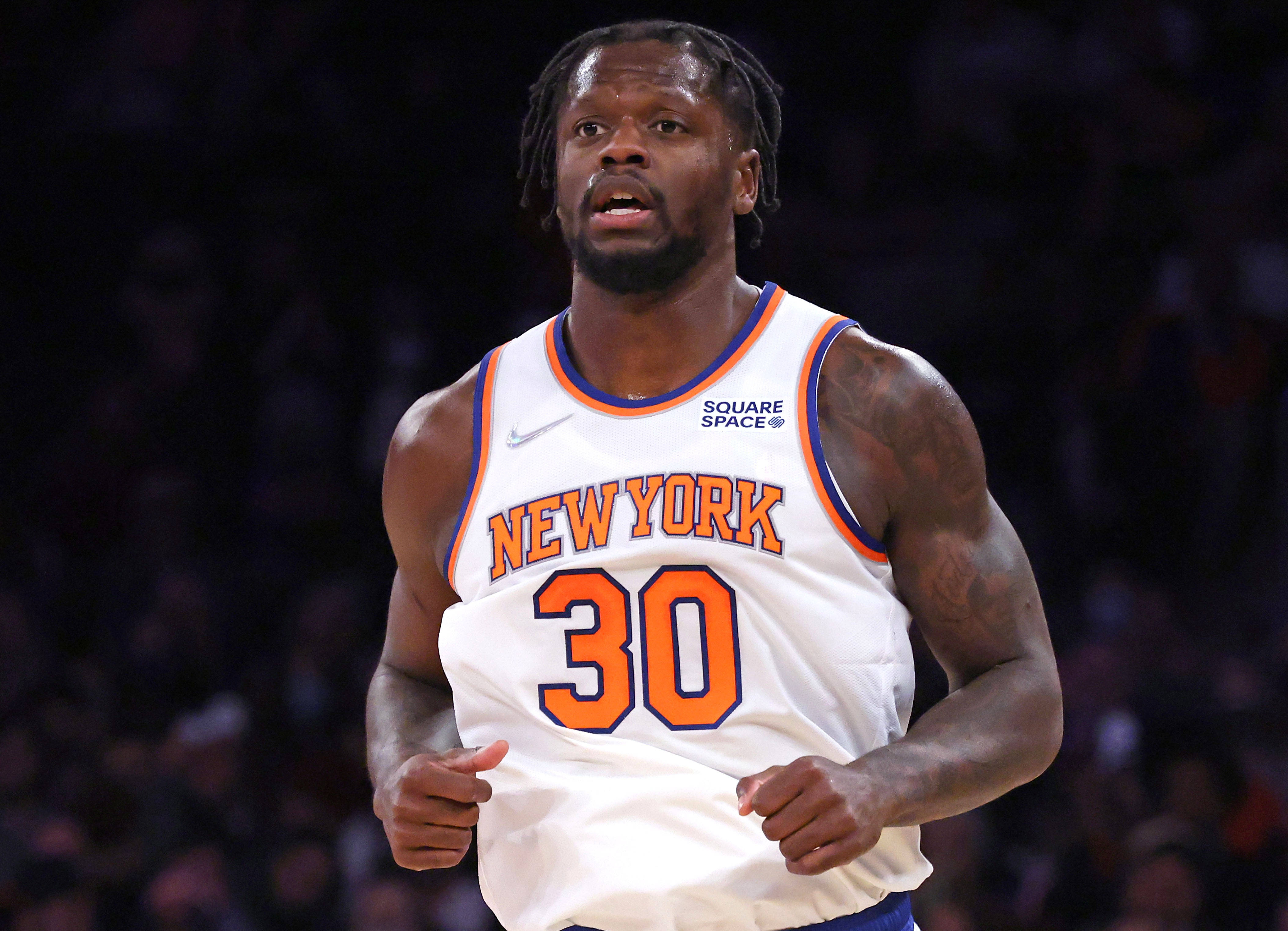 NBA 桌布 壁紙 — 一位專注的籃球運動員，身穿白色紐約球衣，橙色30號，在場館燈光下比賽中衝刺。