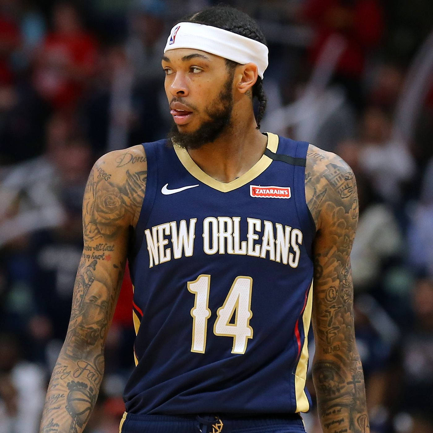 NBA 桌布 壁紙 — 一位專注的籃球運動員，身穿紐奧良球衣，帶有刺青和白色頭帶，正在比賽中。
