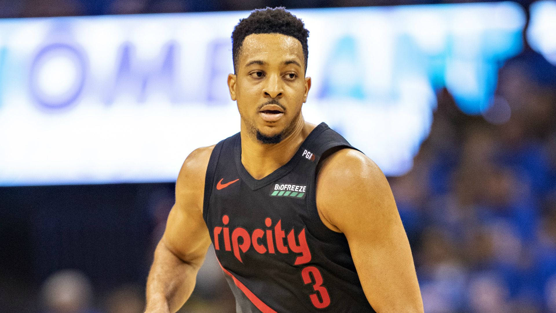Cj 桌布 壁紙 — 一位專注的籃球運動員，身穿黑色 'Rip City' 球衣，帶有紅色字樣和3號，在明亮的場館燈光下準備比賽。