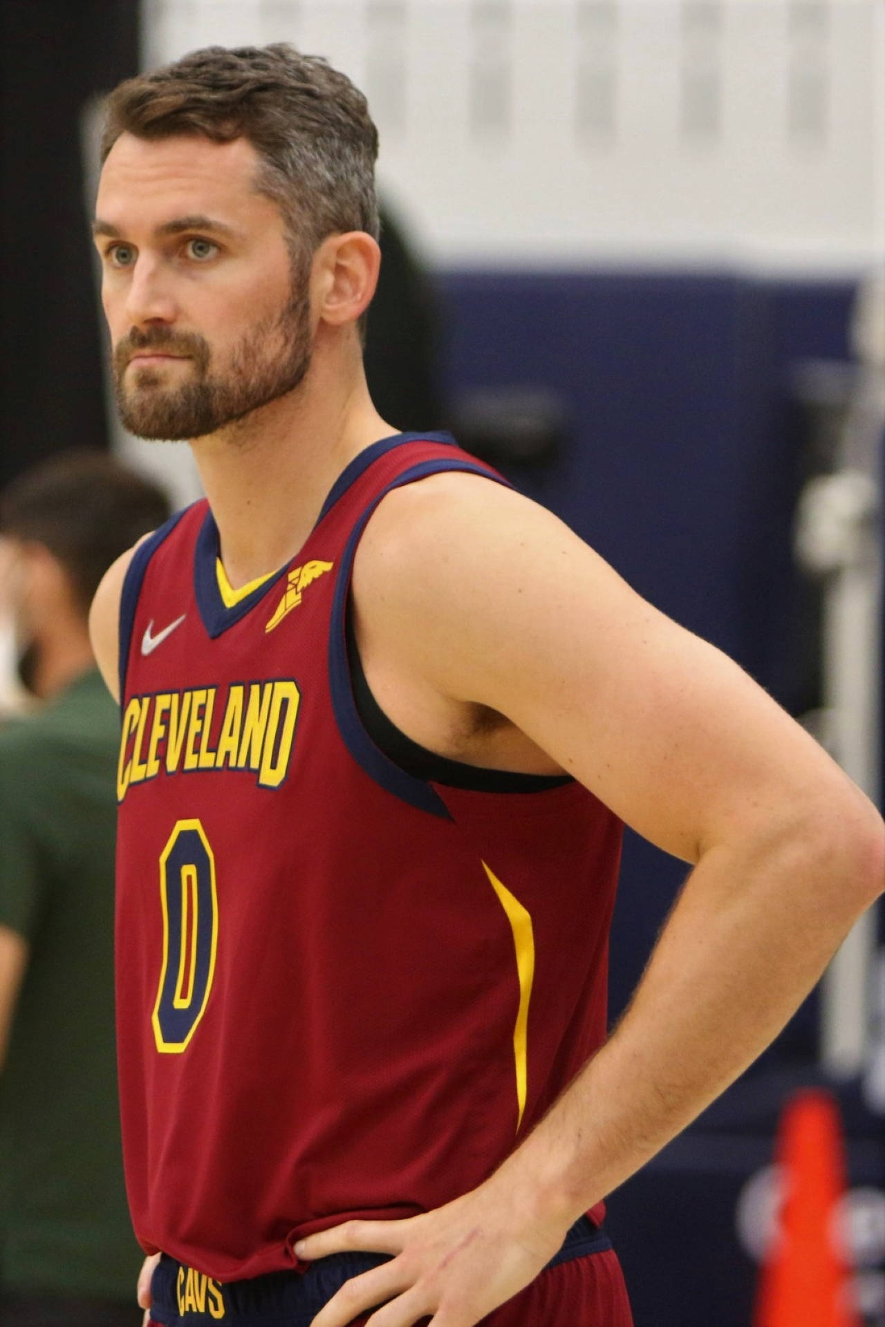 Kevin Love 桌布 壁紙 — 一位專注的籃球運動員穿著栗色克里夫蘭騎士隊球衣，在健身房訓練時雙手叉腰站立。