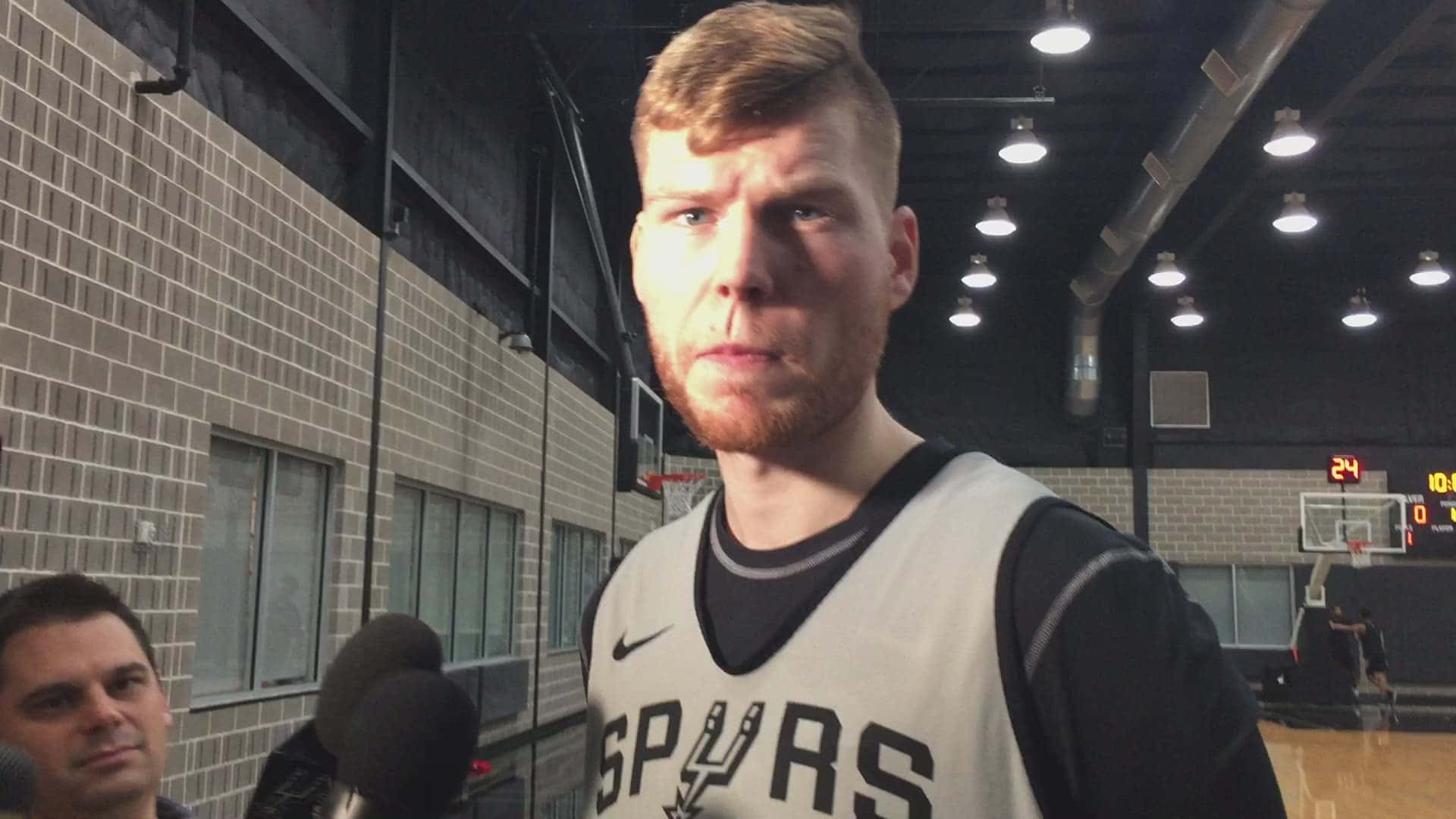 NBA 桌布 壁紙 — 一位專注的籃球運動員身穿Spurs球衣，在體育館內接受記者訪問。