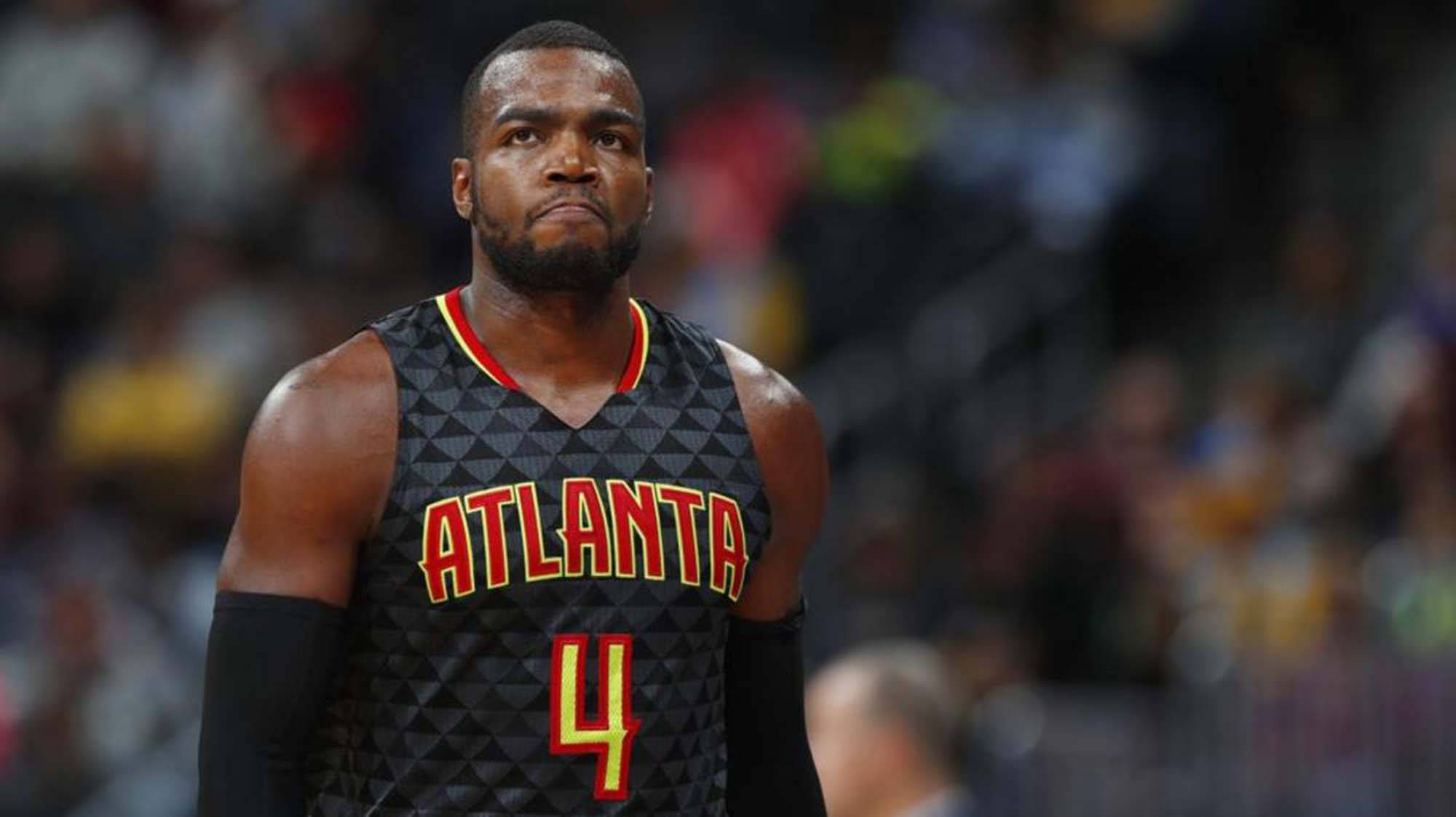 paul millsap 桌布 壁紙 — 一位專注的籃球運動員身穿亞特蘭大球衣，站在球場上，背景是模糊的觀眾。