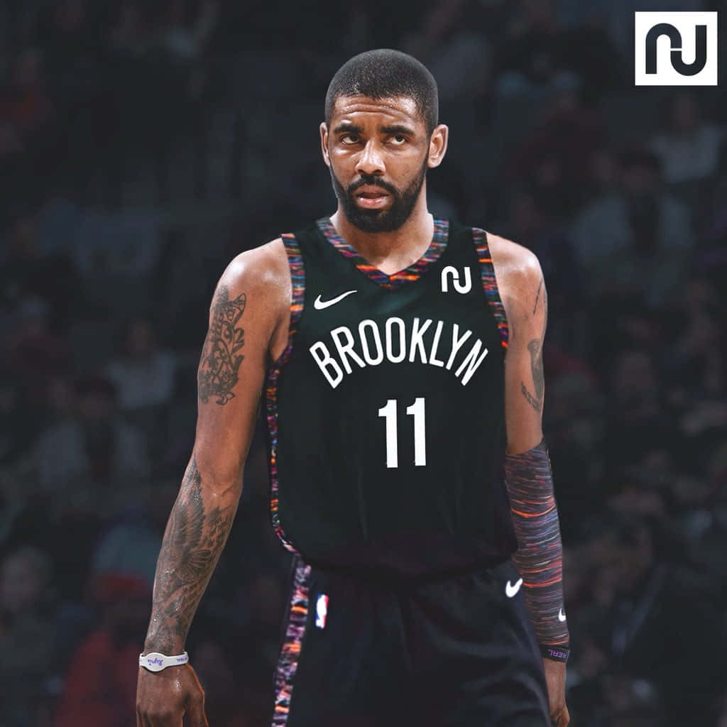 Kyrie Irving Nets 桌布 壁紙 — 一位專注的籃球運動員身穿布魯克林籃網隊球衣，站在球場上，手臂上的刺青清晰可見。