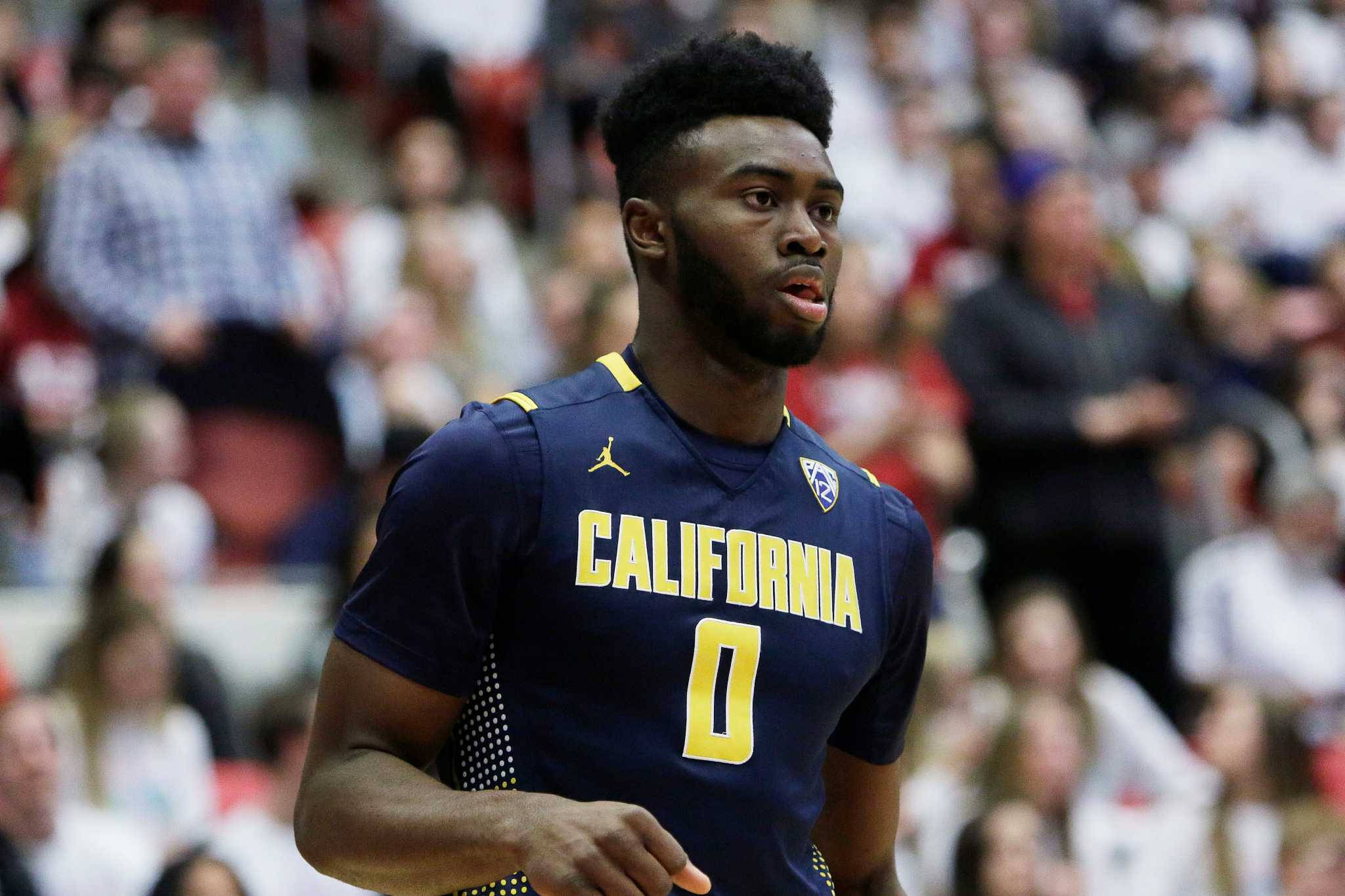 Jaylen Brown 桌布 壁紙 — 一位專注的籃球運動員身穿海軍藍加州球衣，黃色零號，在比賽中奔跑，背景是模糊的觀眾。