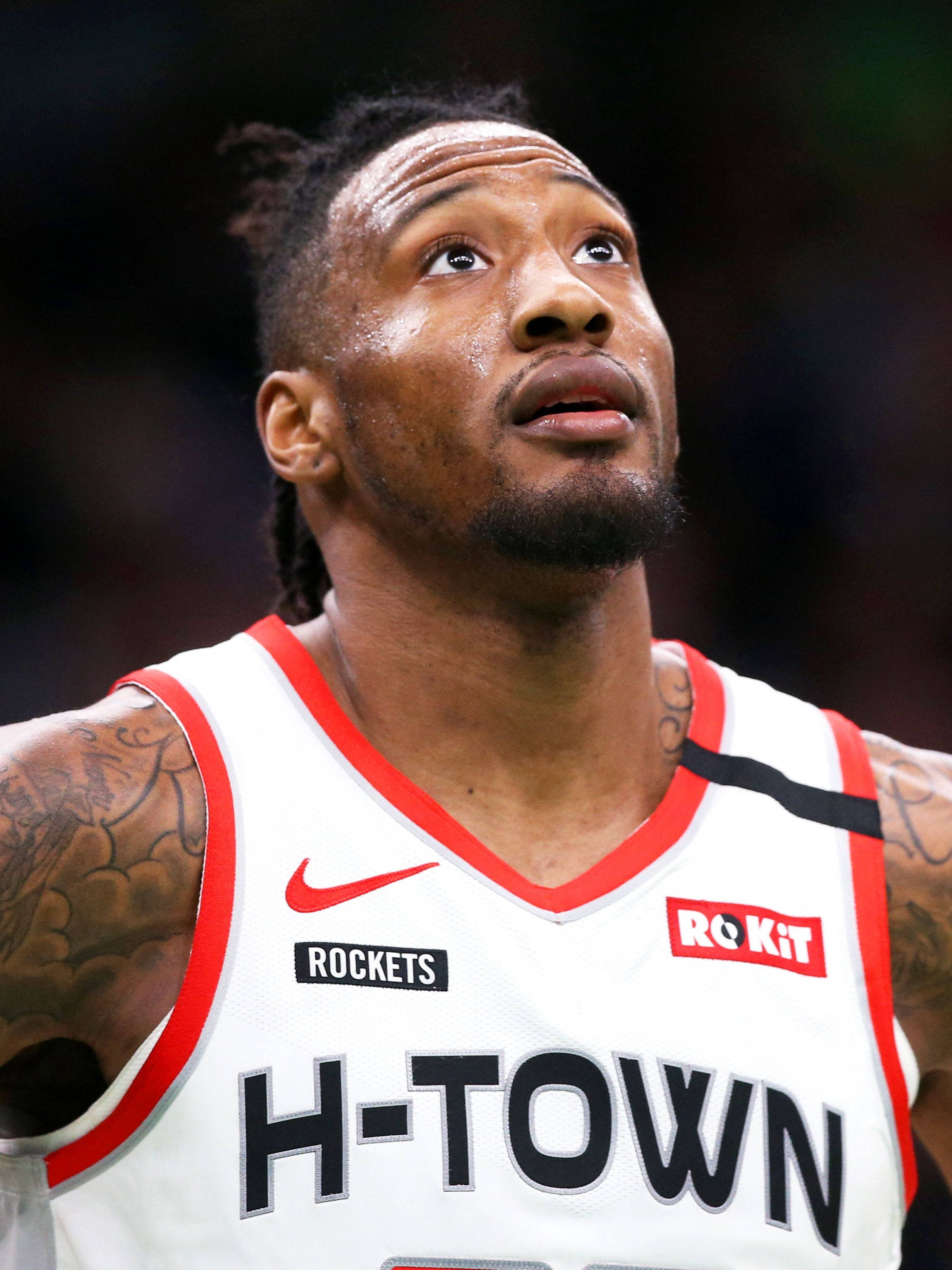 robert covington 桌布 壁紙 — 一位專注的籃球運動員身穿白色H-Town球衣，帶有紅色飾邊，手臂上可見刺青的特寫。