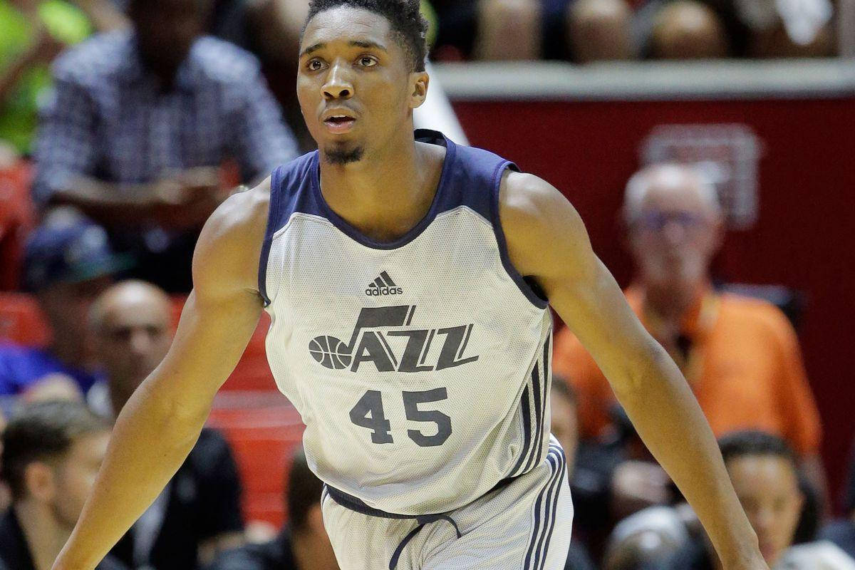 Mitchell 桌布 壁紙 — 一位專注的籃球運動員身穿白色爵士隊45號球衣，在球場上準備就緒，背景是模糊的觀眾。