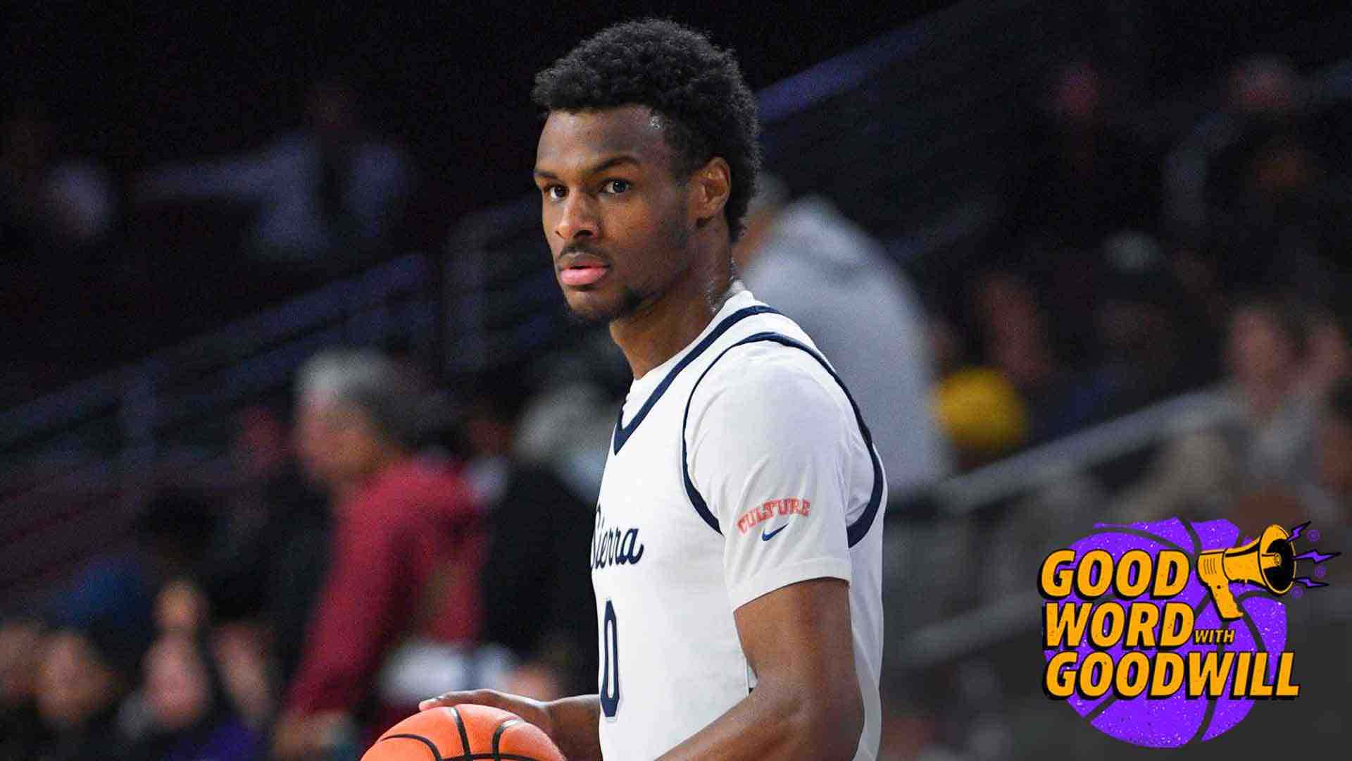 Bronny James 桌布 壁紙 — 一位專注的籃球運動員身穿白色球衣，在場館燈光下拿著橙色籃球，身後是模糊的觀眾。