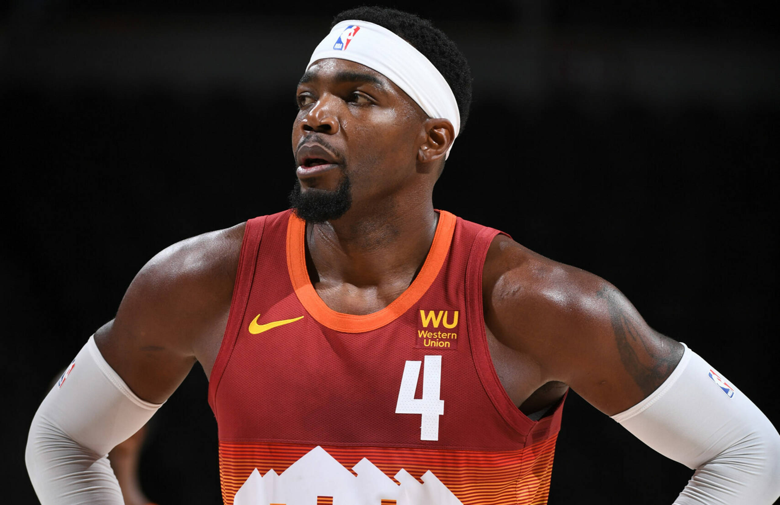 paul millsap 桌布 壁紙 — 一位專注的籃球運動員身穿紅色球衣，號碼四號，戴著白色頭帶，在明亮的場館燈光下比賽中凝視著。
