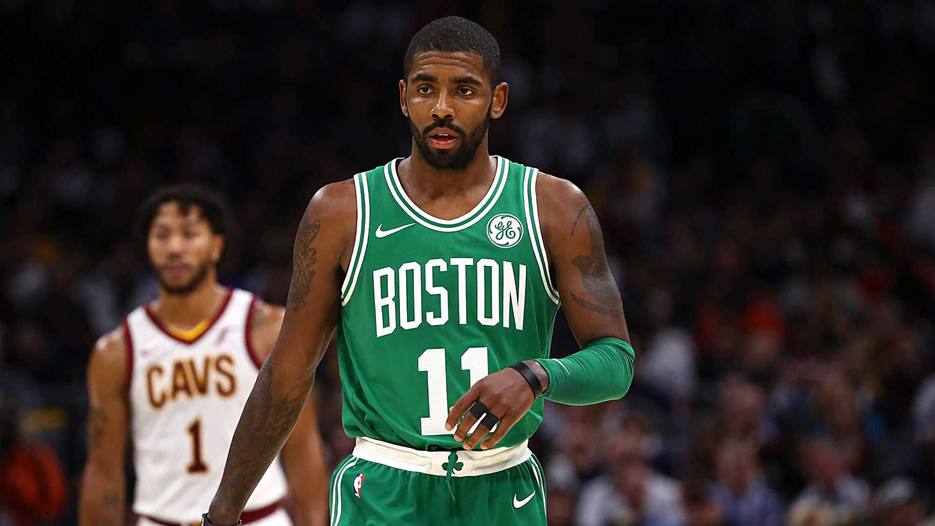 Kyrie 桌布 壁紙 — 一位專注的籃球運動員身穿綠色波士頓球衣，號碼11，站在球場上比賽，身後是模糊的人群。