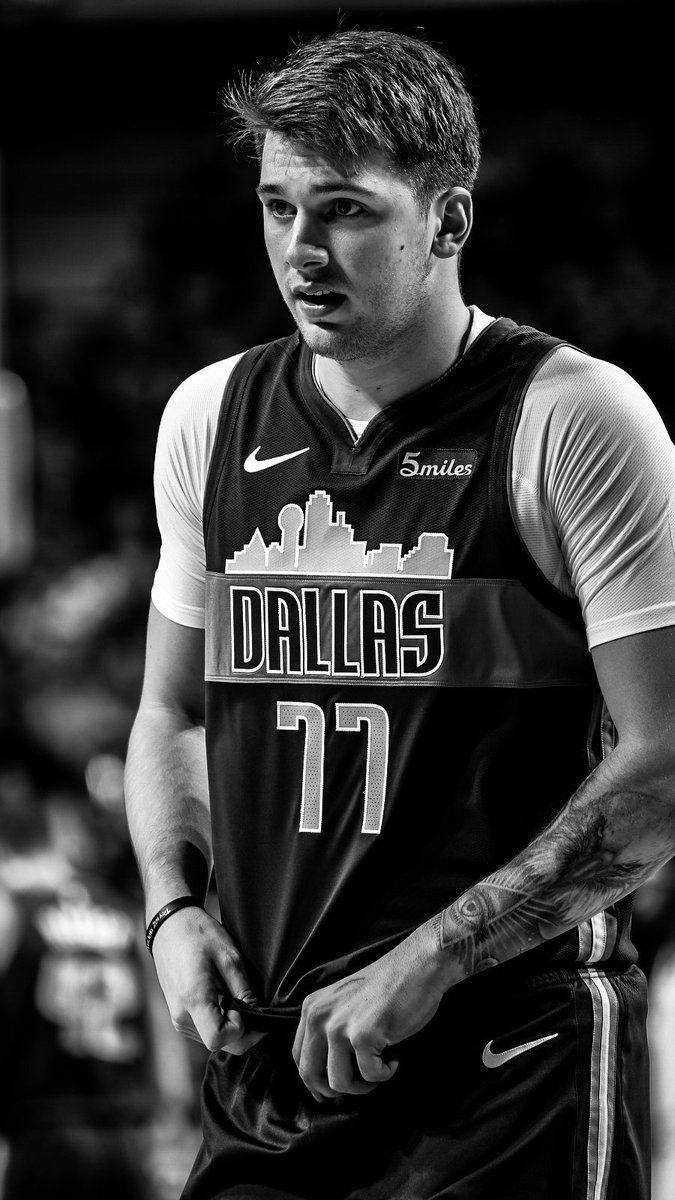 Luka 桌布 壁紙 — 一位專注的籃球運動員身穿達拉斯球衣，手臂上的刺青清晰可見，黑白照片中準備就緒。