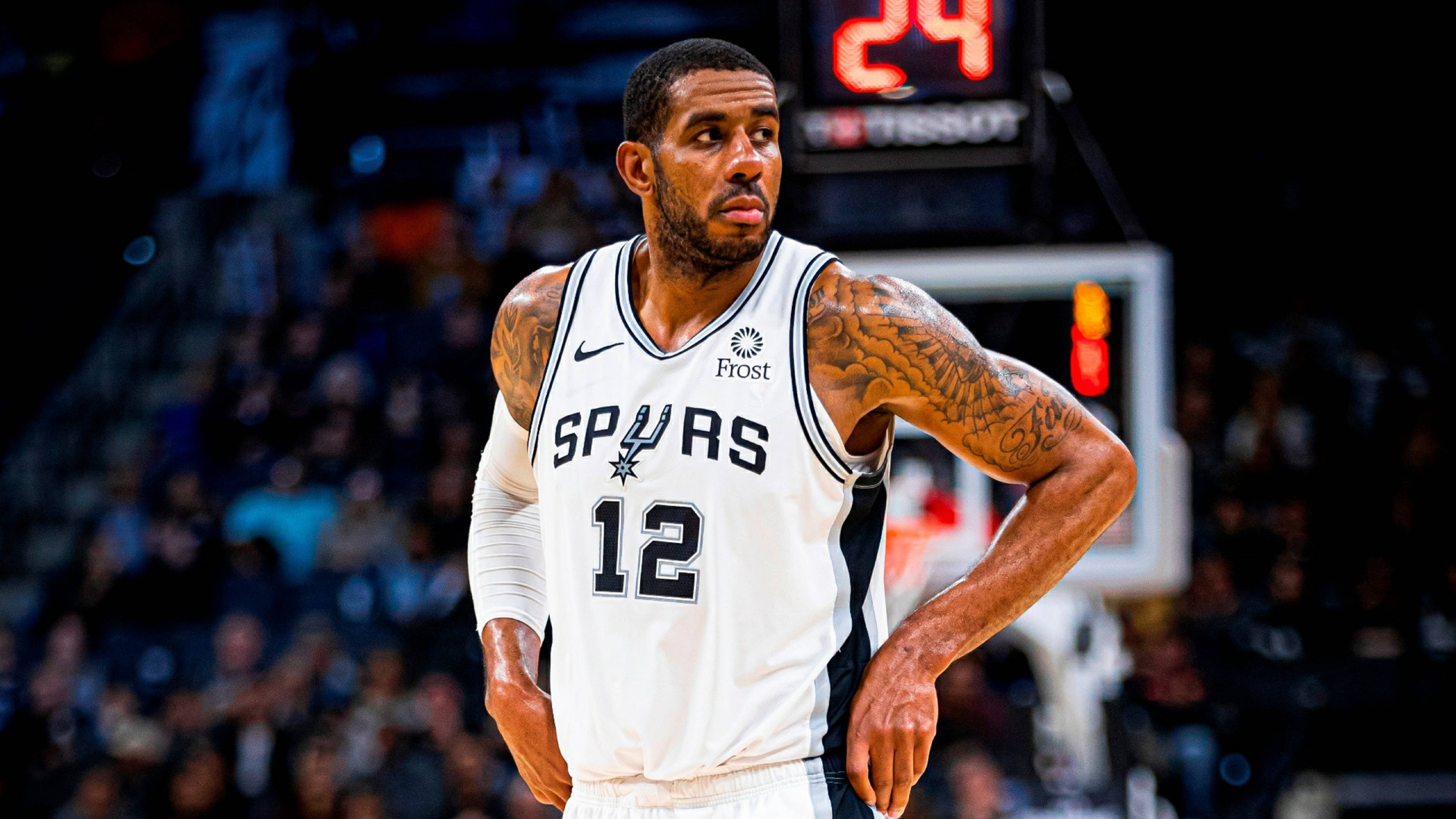 Lamarcus Aldridge 桌布 壁紙 — 一位專注的籃球運動員身穿馬刺球衣站在球場上，紋身在場館燈光下清晰可見。