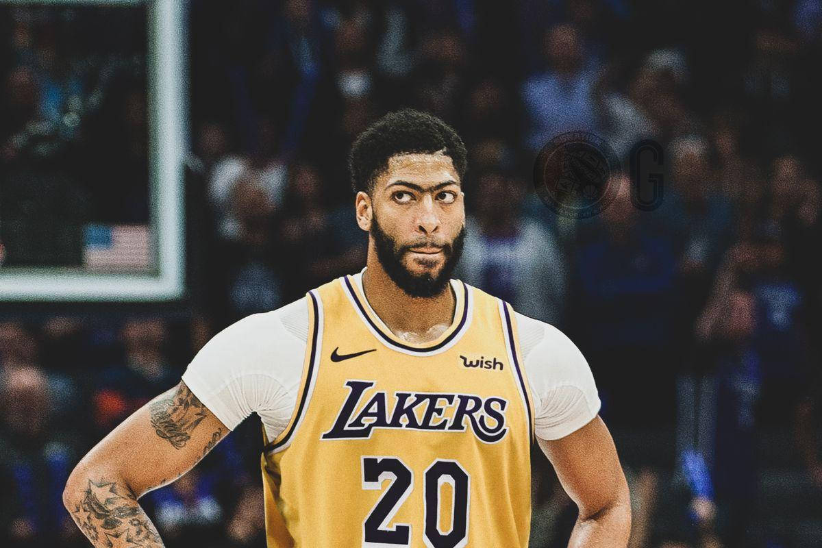 Anthony Davis 桌布 壁紙 — 一位專注的籃球運動員身穿黃色湖人隊20號球衣，站在球場上，背景是模糊的觀眾。
