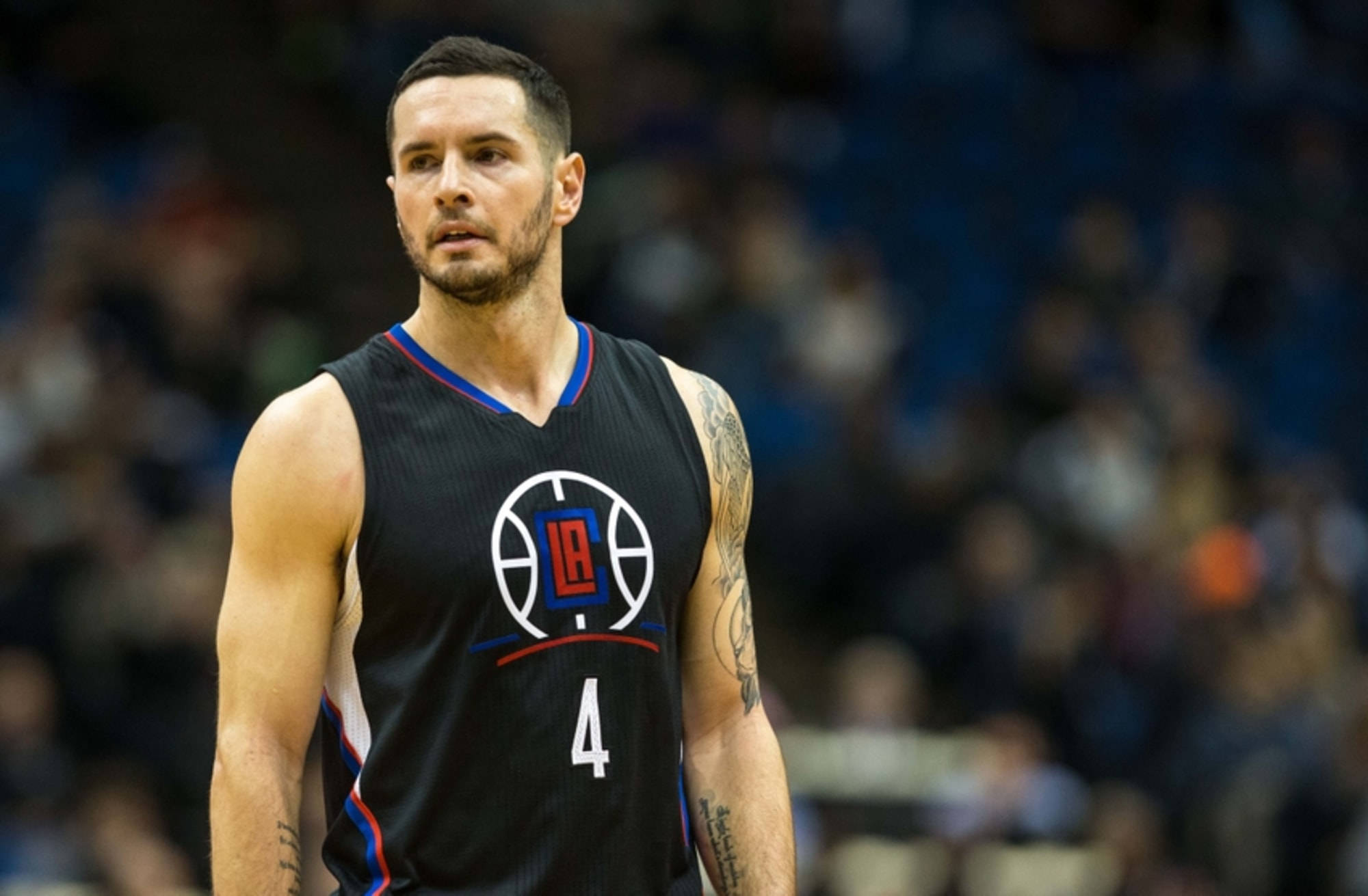 Jj Redick 桌布 壁紙 — 一位專注的籃球運動員身穿黑色LA Clippers 4號球衣，站在球場上，背景是模糊的觀眾。