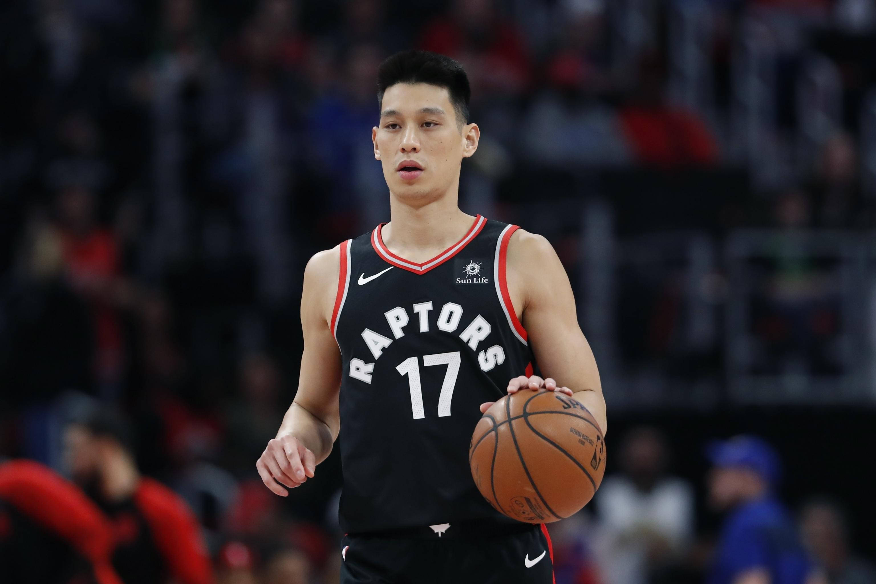Lin 桌布 壁紙 — 一位專注的籃球運動員身穿黑色Raptors球衣，在場館燈光下比賽中持球。