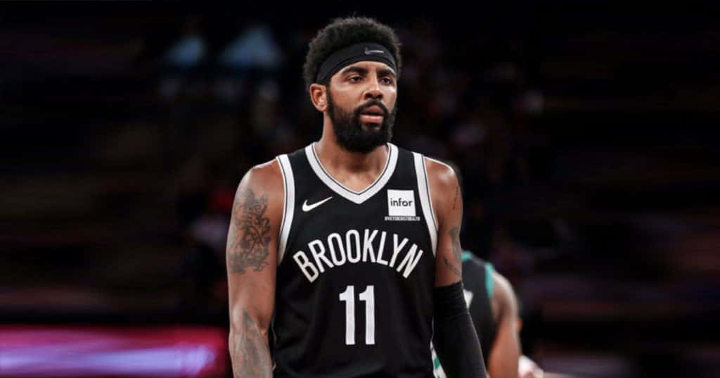 Kyrie Irving Nets 桌布 壁紙 — 一位專注的籃球運動員身穿黑色布魯克林球衣，號碼11，站在明亮的場館燈光下的球場上。