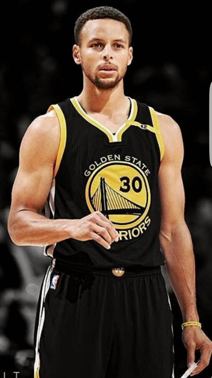 Curry 桌布 壁紙 — 一位專注的籃球運動員身穿黑色金州勇士隊30號球衣，在明亮的場館燈光下準備就緒。