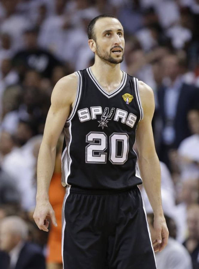 Manu 桌布 壁紙 — 一位專注的籃球運動員身穿黑色馬刺隊20號球衣，在比賽中站在球場上，身後是模糊的人群。