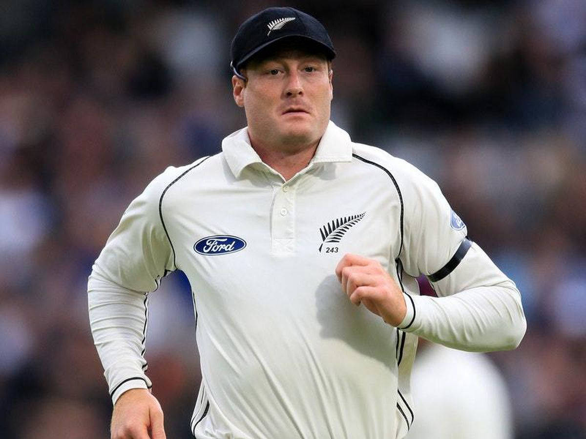 martin guptill 桌布 壁紙 — 一位專注的紐西蘭板球運動員身穿白色制服在場地上奔跑，背景是模糊的觀眾。