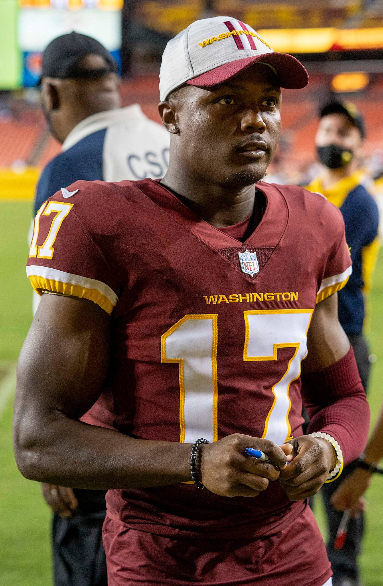Football Players 桌布 壁紙 — 一位專注的華盛頓美式足球隊球員，身穿棗紅色17號球衣，在明亮的球場上比賽。