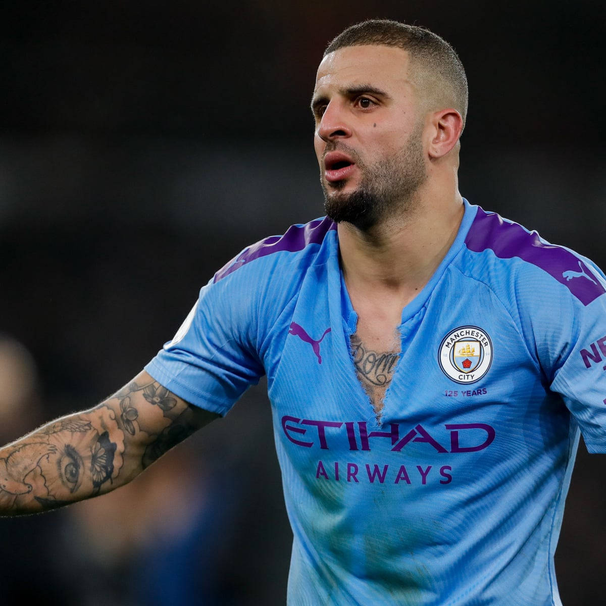 Kyle Walker 桌布 壁紙 — 一位專注的足球員，身穿淺藍色曼城球衣，帶有紫色點綴，手臂上有明顯的刺青。