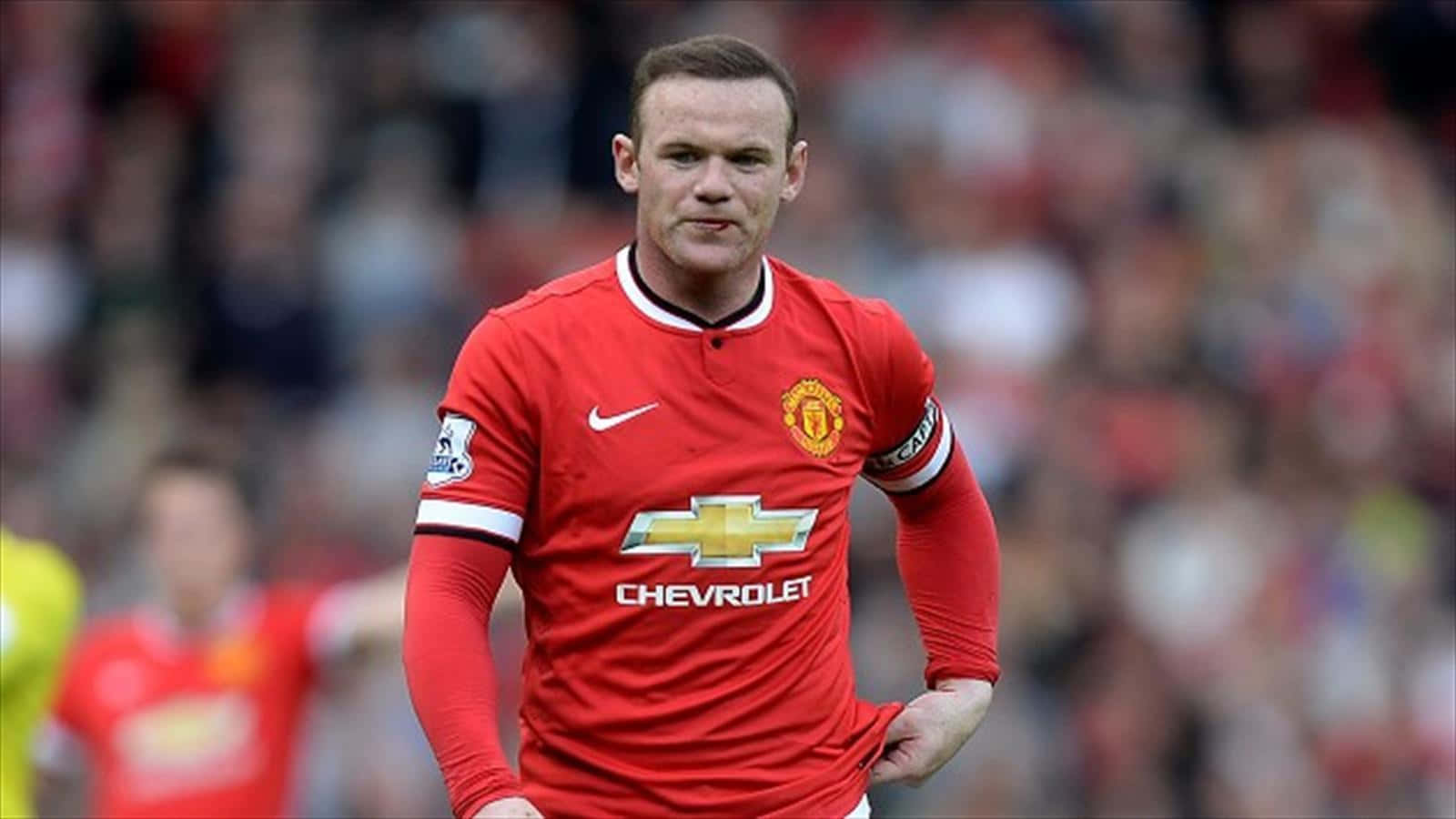 Football Player 桌布 壁紙 — 一位專注的足球員身穿紅色曼聯球衣，在比賽中堅定地向前邁進。