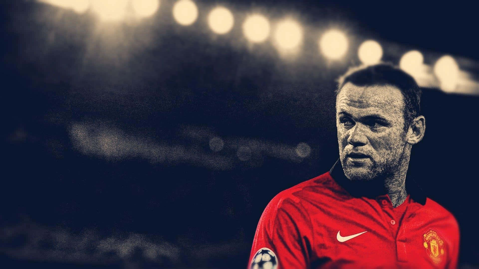 Rooney 桌布 壁紙 — 一位專注的足球員身穿紅色曼聯球衣，在球場燈光下帶著堅毅決定的表情站立。
