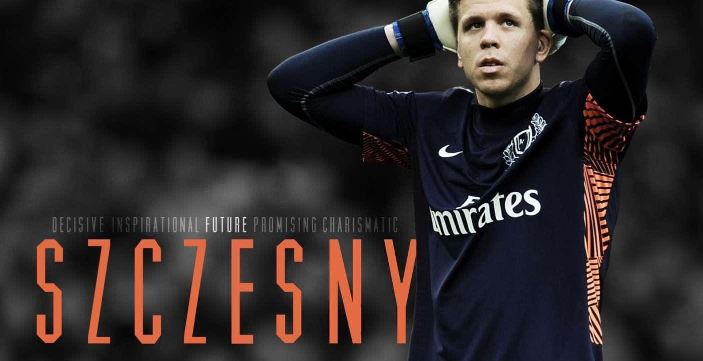 Wojciech Szczesny 桌布 壁紙 — 一位專注的足球守門員身穿深藍色球衣帶橙色點綴，雙手放在頭上，背景是模糊的球場。