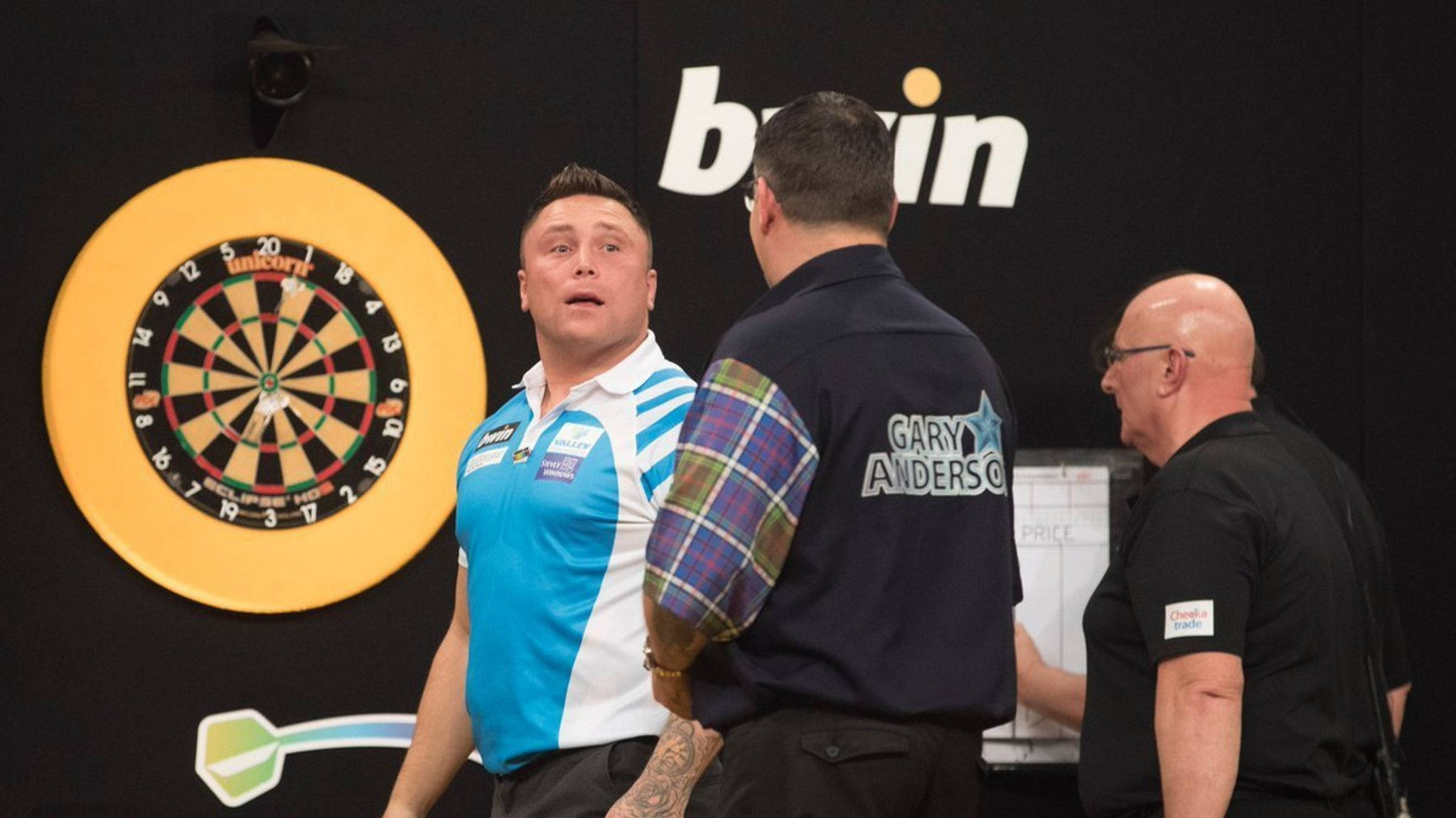 darts 桌布 壁紙 — 一位專注的飛鏢選手穿著藍色襯衫，在專業錦標賽中向明亮的黃色飛鏢靶投擲飛鏢後作出反應。