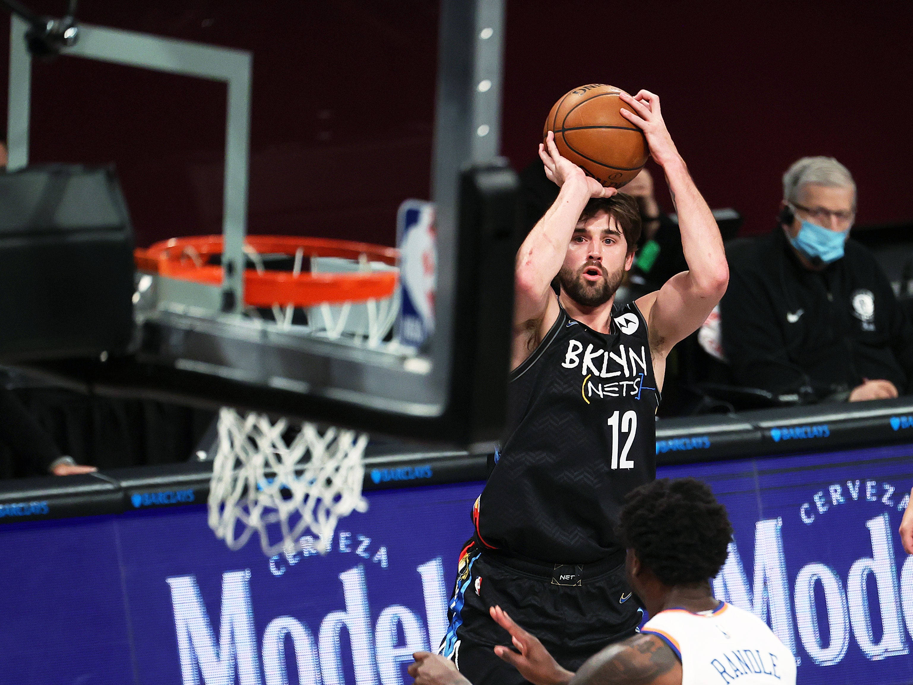 joe harris 桌布 壁紙 — 一位布魯克林籃網隊球員身穿黑色球衣，在明亮的場館燈光下於一場激烈的NBA比賽中投籃。