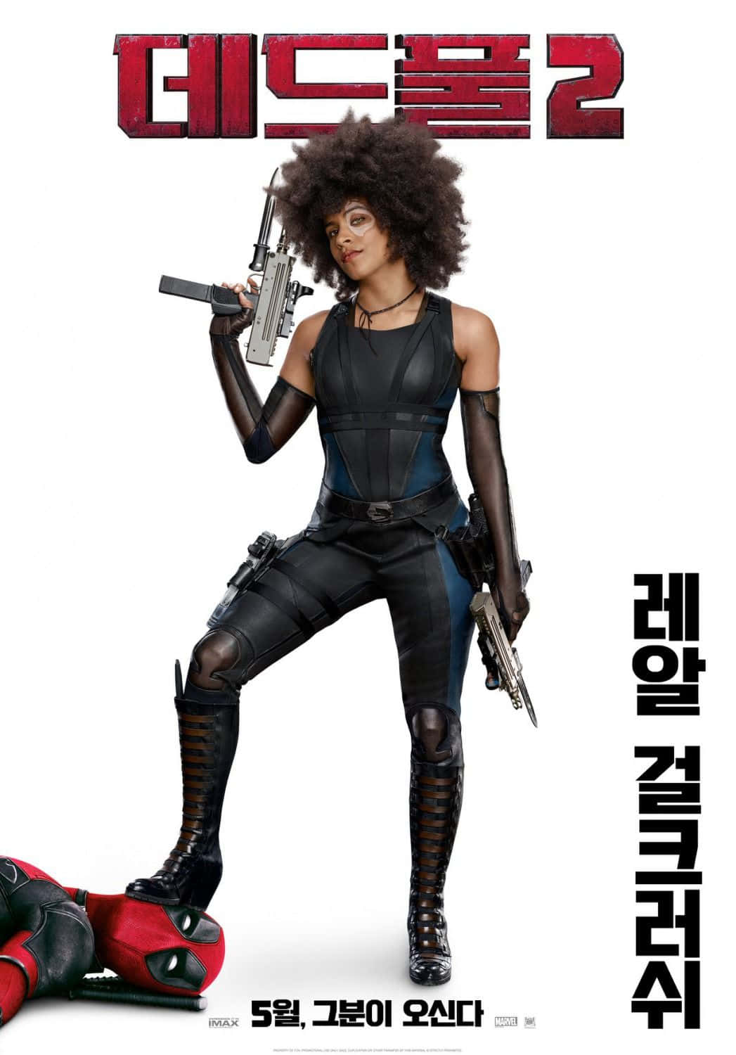 Deadpool And Domino 桌布 壁紙 — 一位帶有非洲式髮型的兇猛女性，身穿黑色和藍色戰術服裝，站在倒下的死侍身上，手持兩把槍。