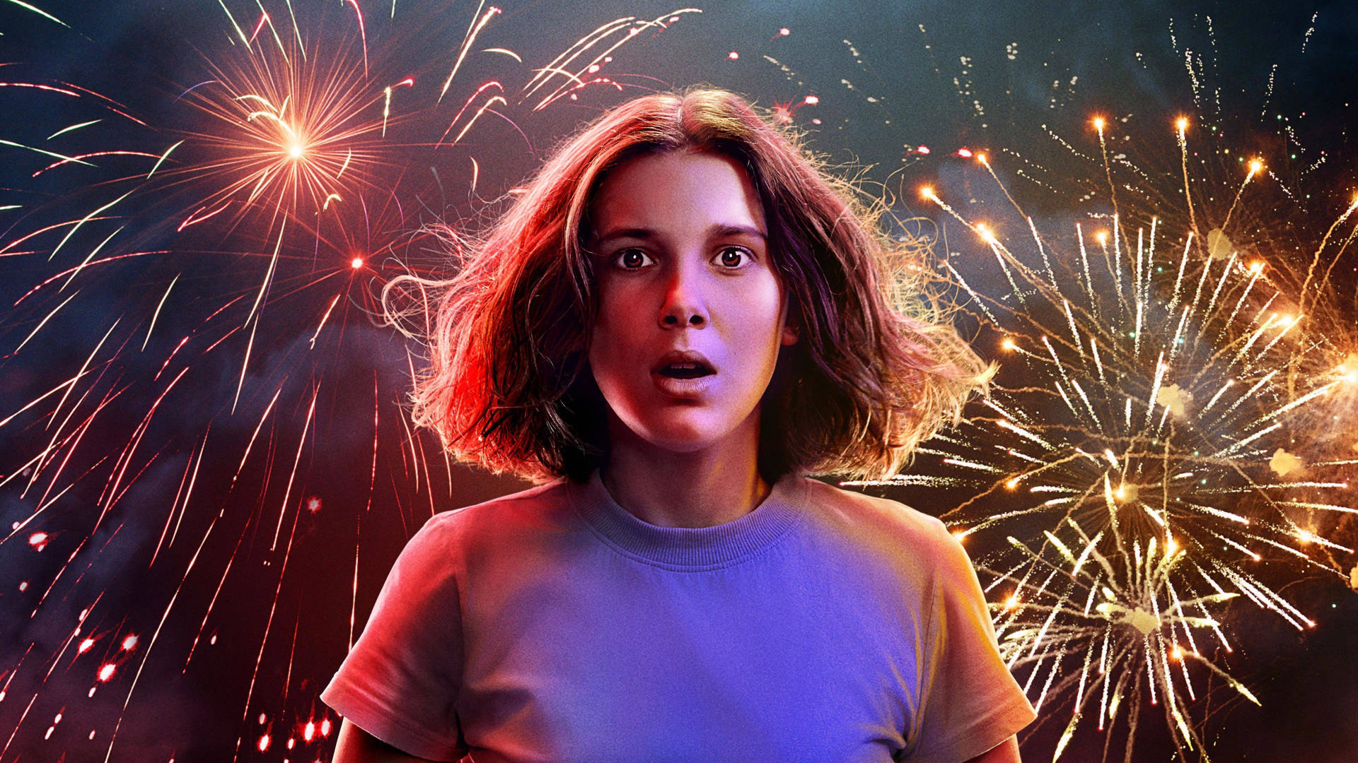 Aesthetic Stranger Things Eleven 桌布 壁紙 — 一位年輕女子睜大眼睛，震驚地凝視著背景中爆炸的煙火照亮夜空。