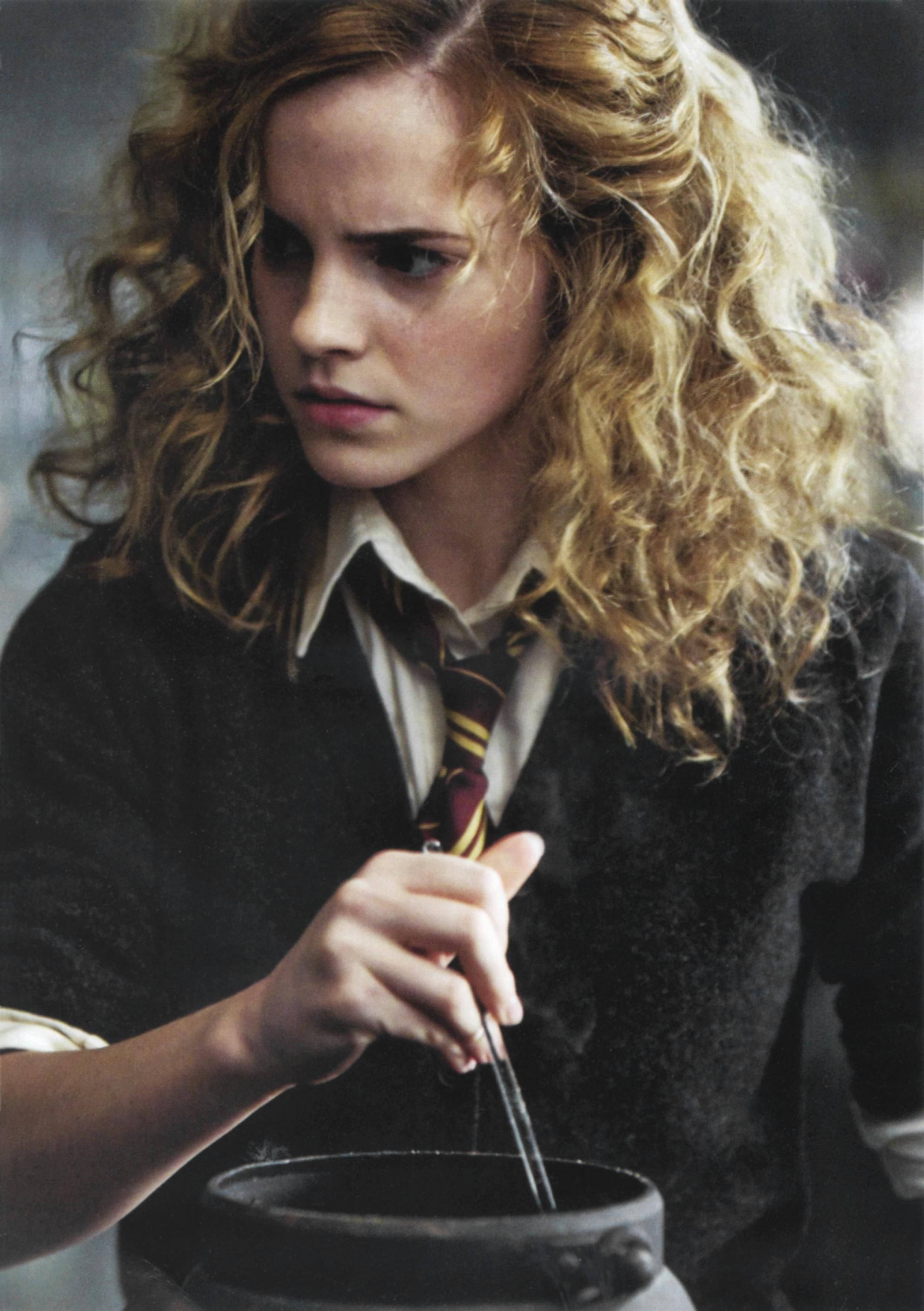 Hermione 桌布 壁紙 — 一位年輕女巫，金色捲髮，穿著霍格華茲制服，攪拌大鍋中的藥水。