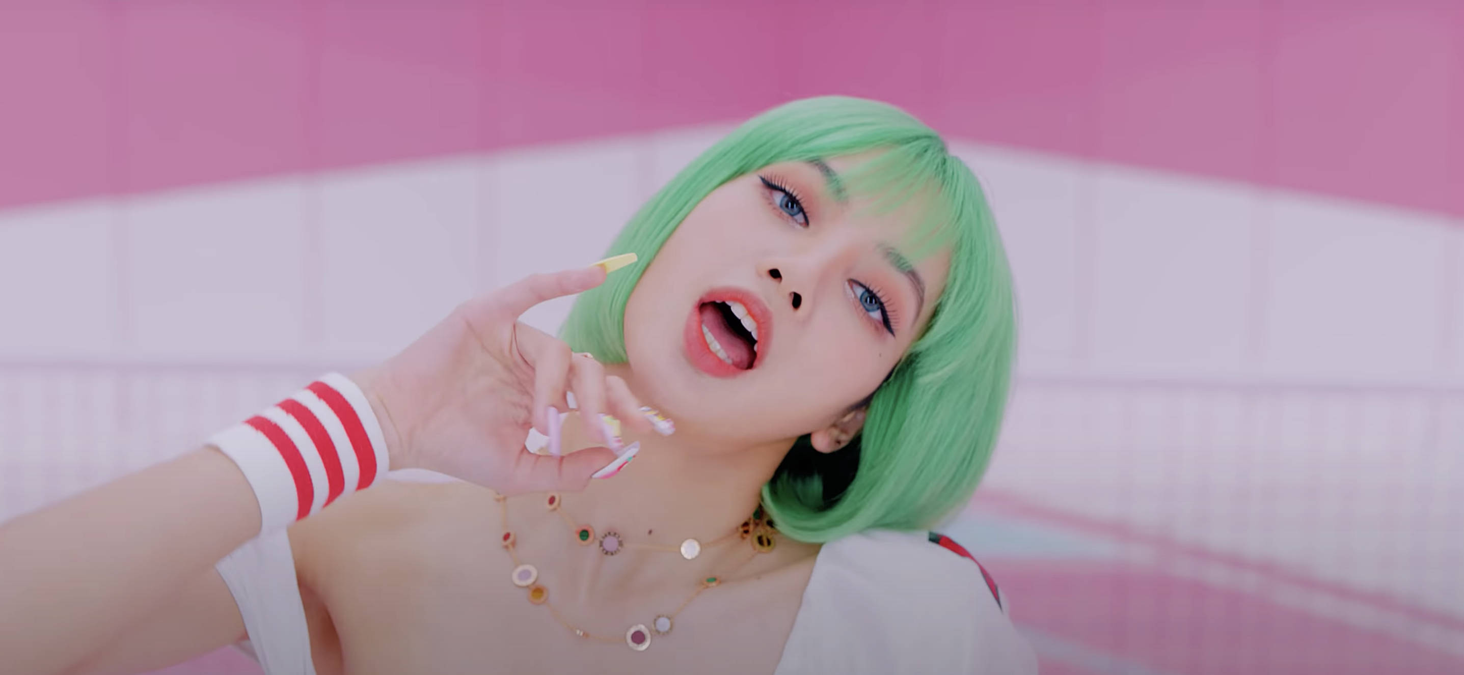 Lalisa 桌布 壁紙 — 一位年輕女性，擁有充滿活力的綠色頭髮和大膽的妝容，在粉白瓷磚牆前俏皮地擺姿勢。