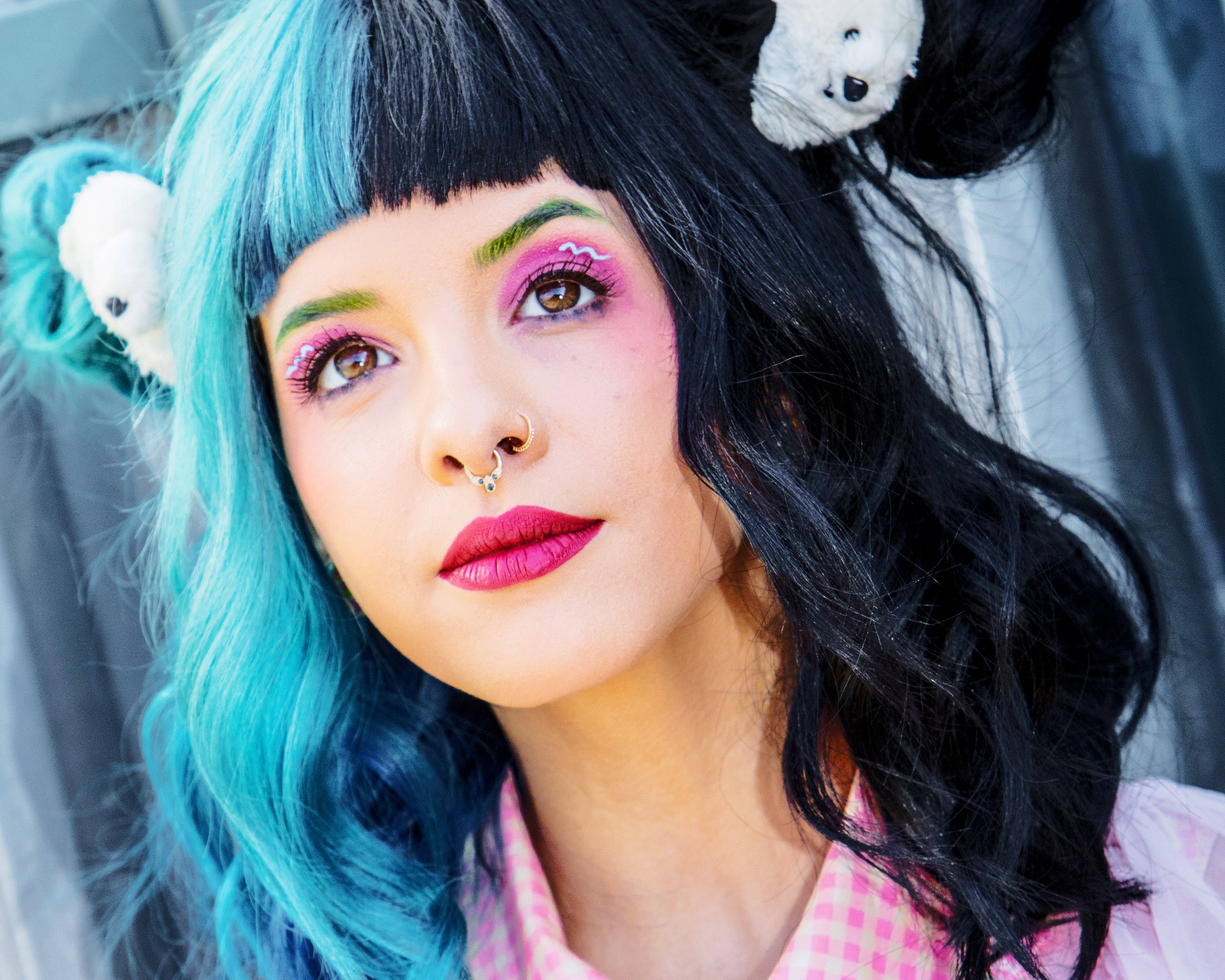 Melanie 桌布 壁紙 — 一位年輕女性，擁有鮮豔的藍色頭髮和粉紅色化妝，戴著小熊髮夾，溫柔地凝視著。