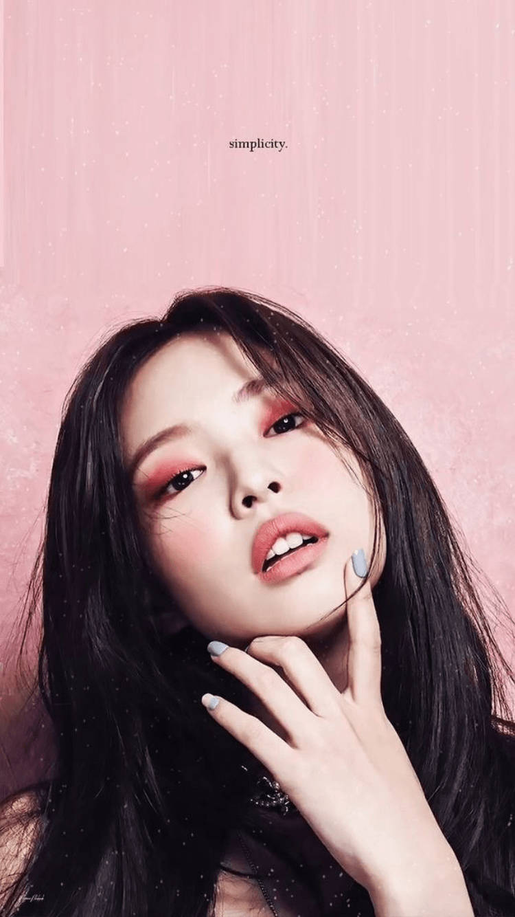 Jennie 桌布 壁紙 — 一位年輕女性，深色頭髮，柔和粉紅妝容，在帶有紋理的粉紅背景上仰望，背景上有「簡約」一詞。