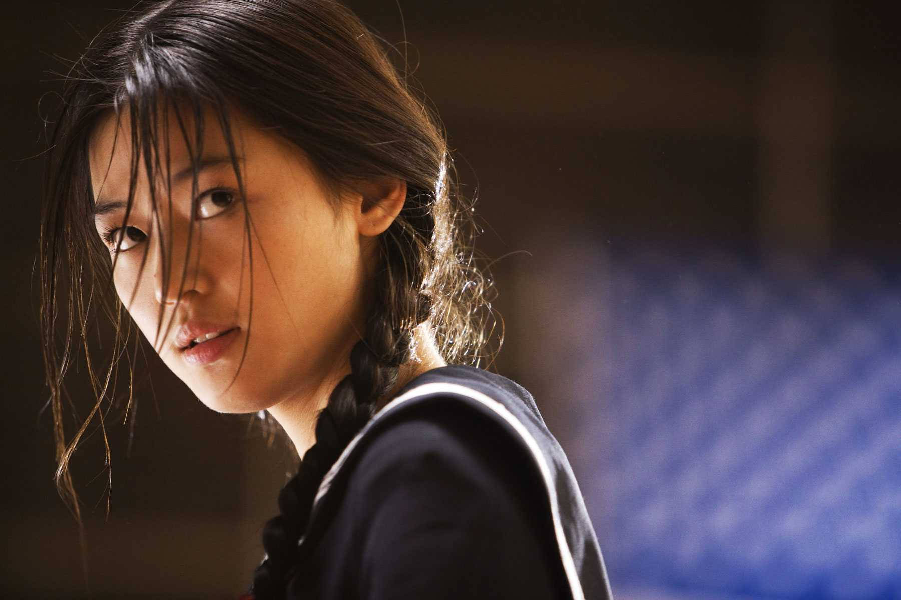 Jun Ji Hyun 桌布 壁紙 — 一位年輕女性，濕髮編辮，在昏暗的室內環境中凝視著肩膀後方。