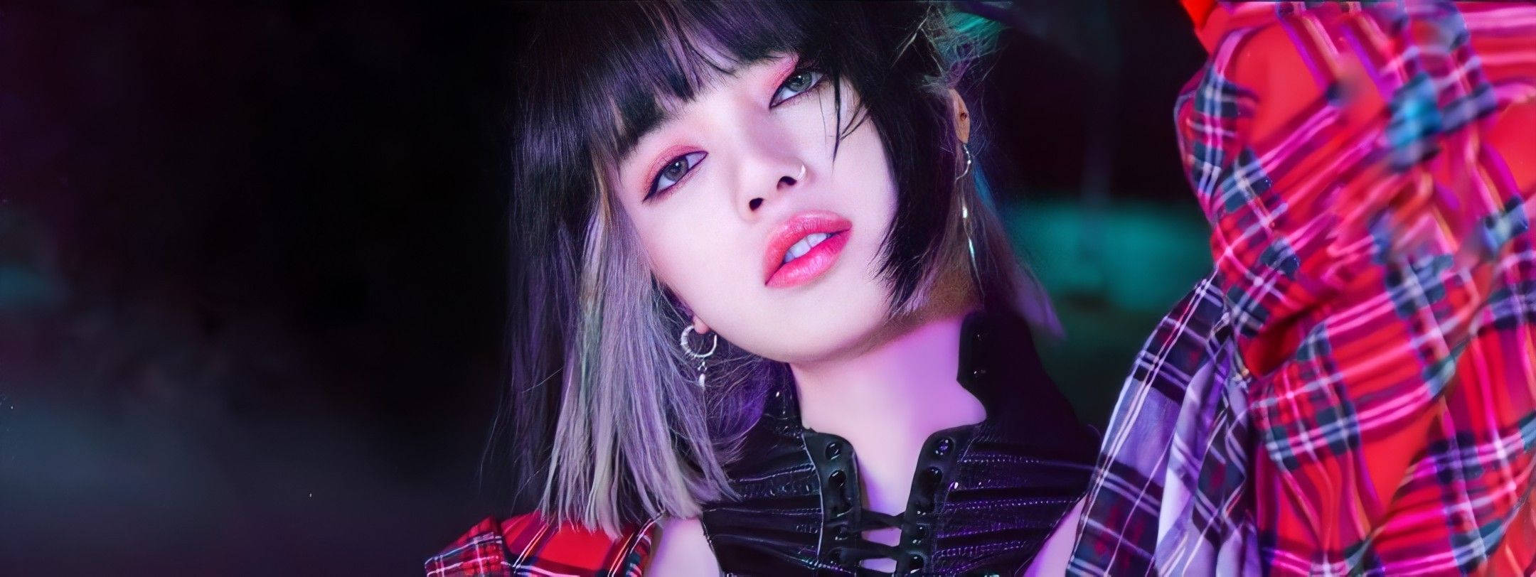 Lalisa 桌布 壁紙 — 一位年輕女性，短髮層次分明，妝容大膽，身穿紅色格紋襯衫，外搭黑色束腰，眼神銳利。