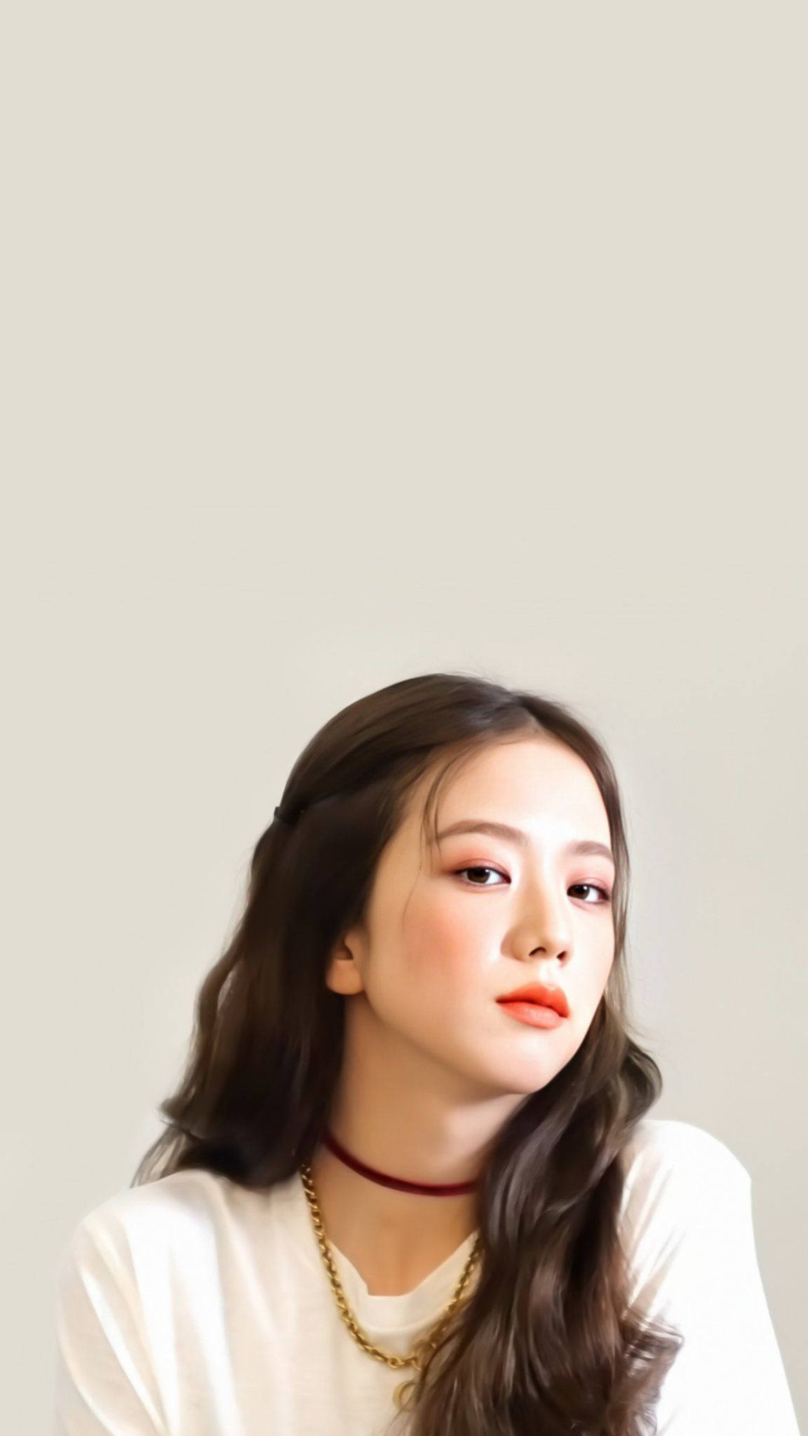 Jisoo Cute 桌布 壁紙 — 一位年輕女性，長長的波浪形棕色頭髮，溫柔地向上望，背景是純色淺米色。