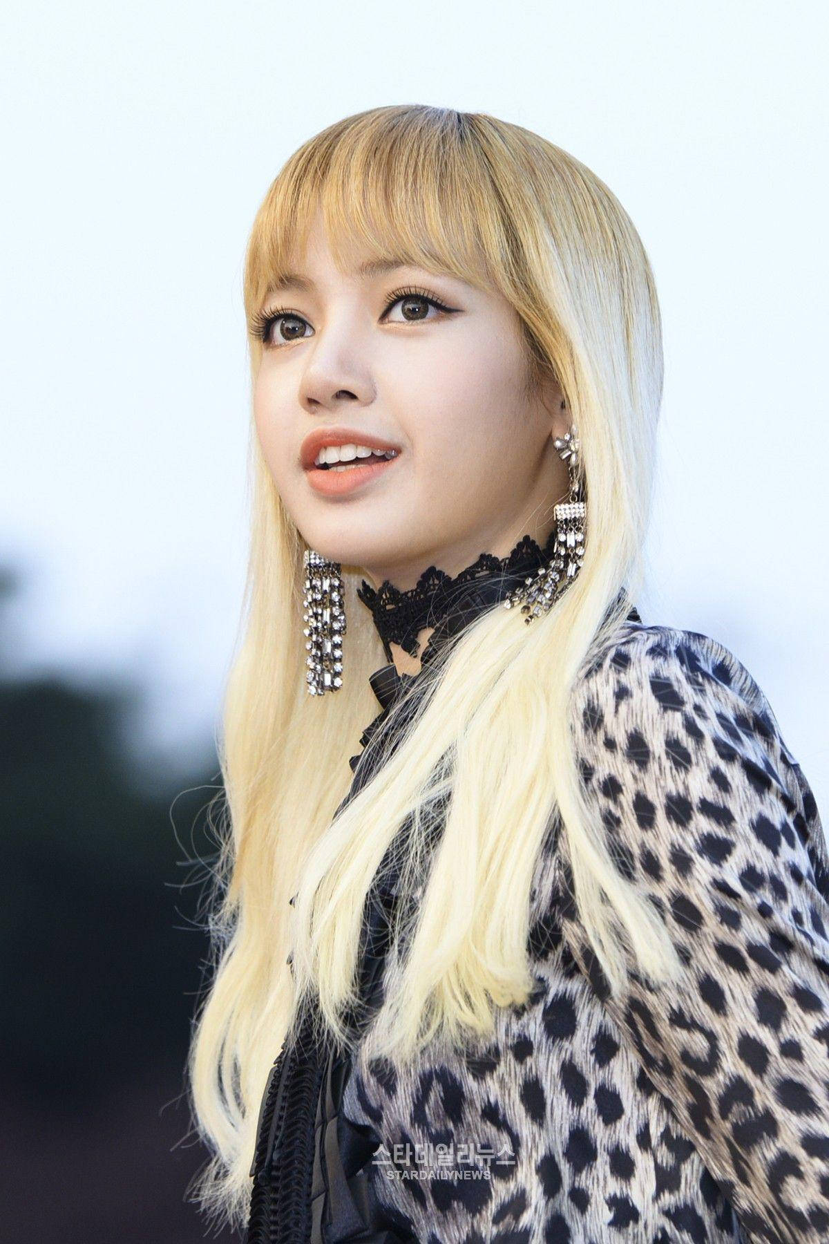 金髮女性穿著豹紋服裝，戴著閃閃發光的耳環，在戶外微笑。 — BLACKPINK Lisa GIF 壁紙