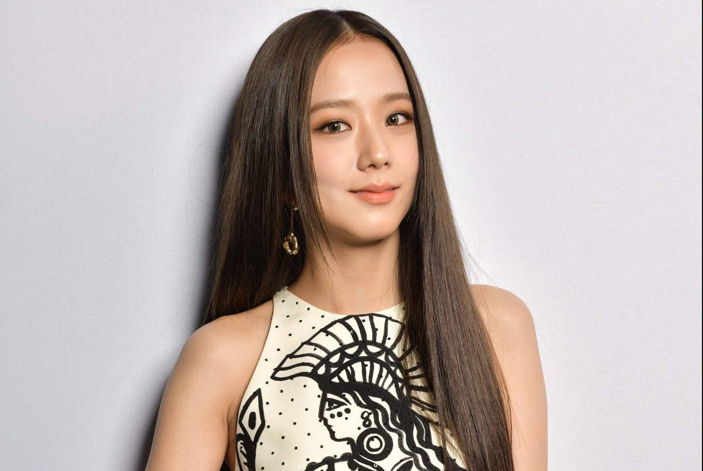 年輕女性，長長的黑髮，穿著帶有黑色部落圖案的奶油色上衣和金色耳環。 — 智秀 GIF 壁紙