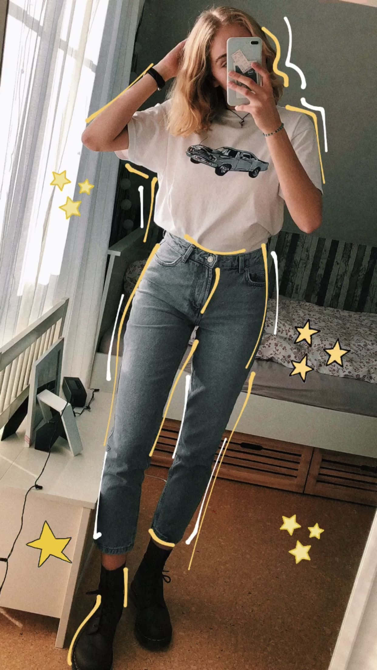 Clothes 桌布 壁紙 — 一位年輕女性在臥室裡對著鏡子自拍，穿著汽車圖案T恤和帶有黃色塗鴉點綴和星星貼紙的牛仔褲。